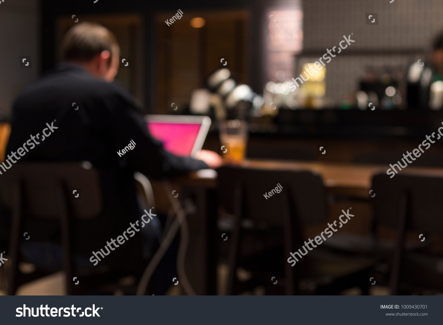Blurry background of a man working in coffee shop #1009430701
