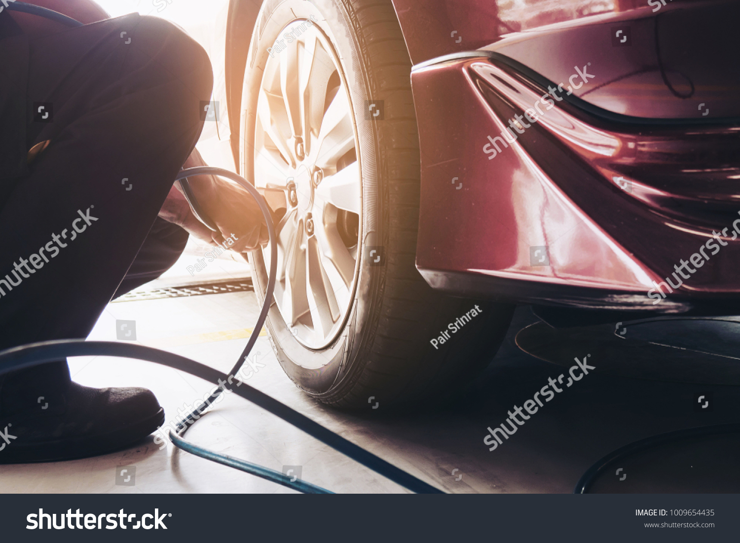Technician is inflate car tire - car maintenance service transportation safety concept #1009654435