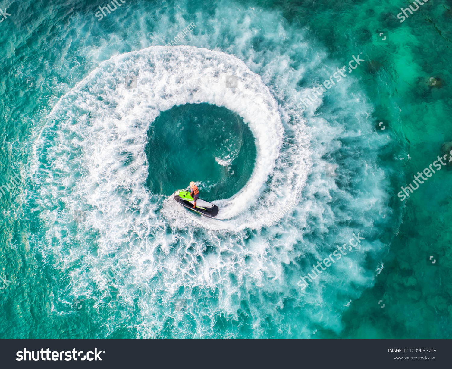 People are playing a jet ski in the sea.Aerial view. Top view.amazing nature background.The color of the water and beautifully bright. Fresh freedom. Adventure day.clear turquoise at tropical beach. #1009685749