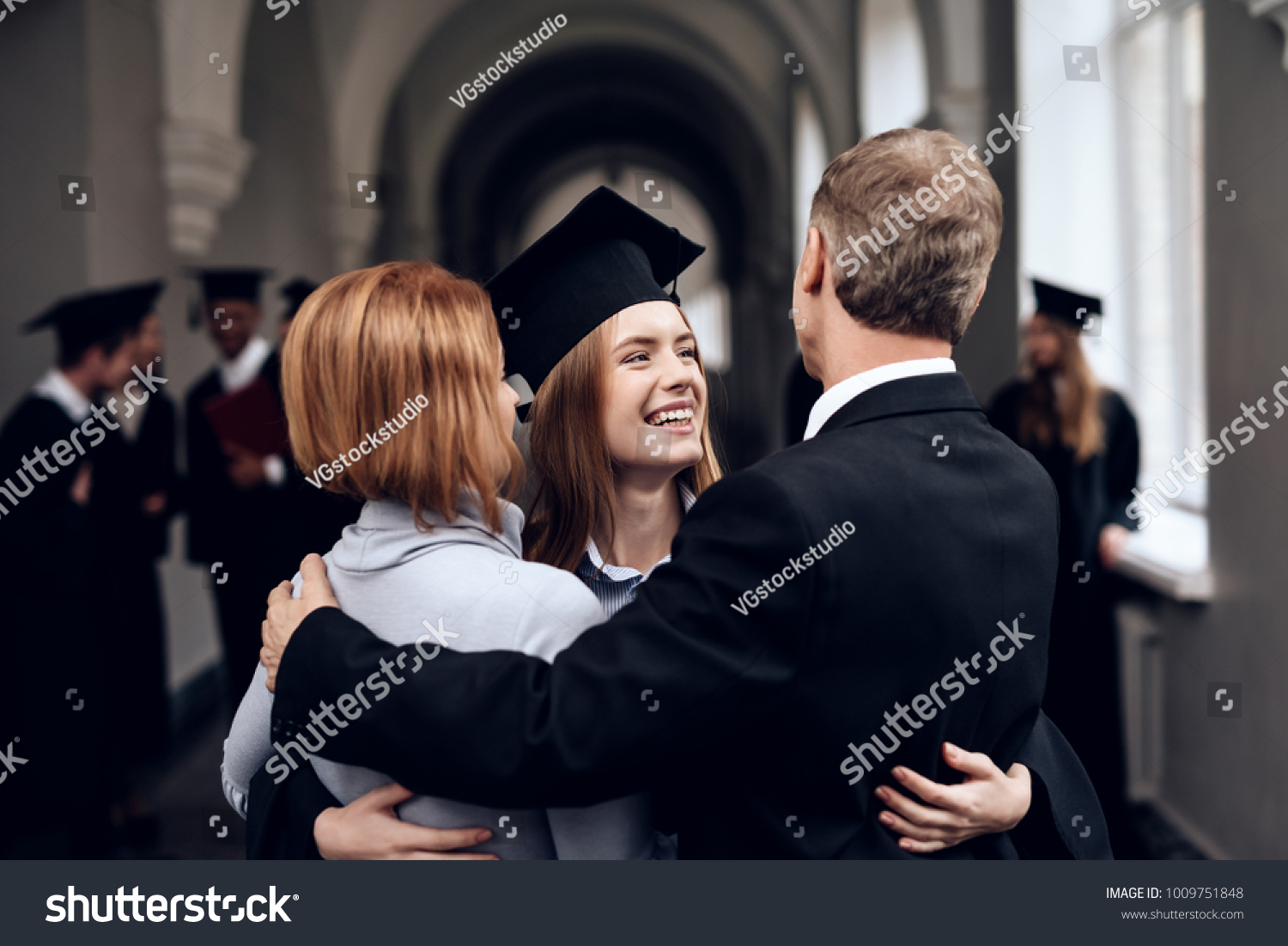 Parents congratulate the student, who finish their studies at the university. He graduates. They are very happy about this. #1009751848