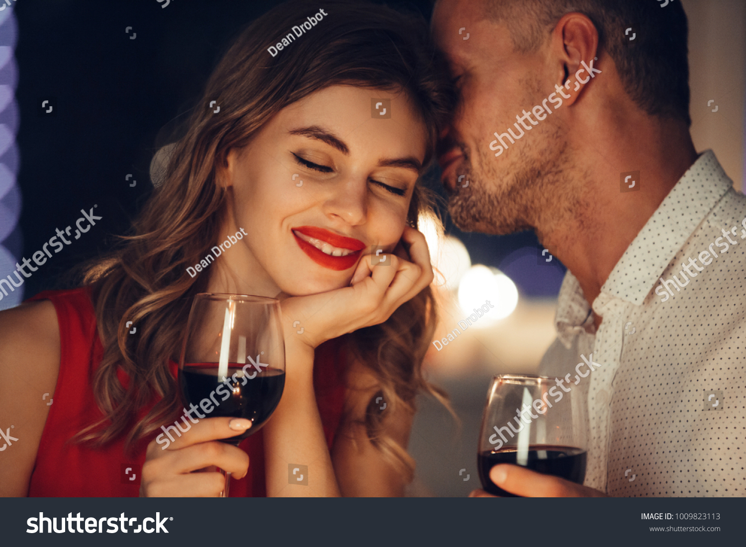 Young handsome man whisper to his gorgeous woman while have romantic dinner and drinking wine on valentines day #1009823113