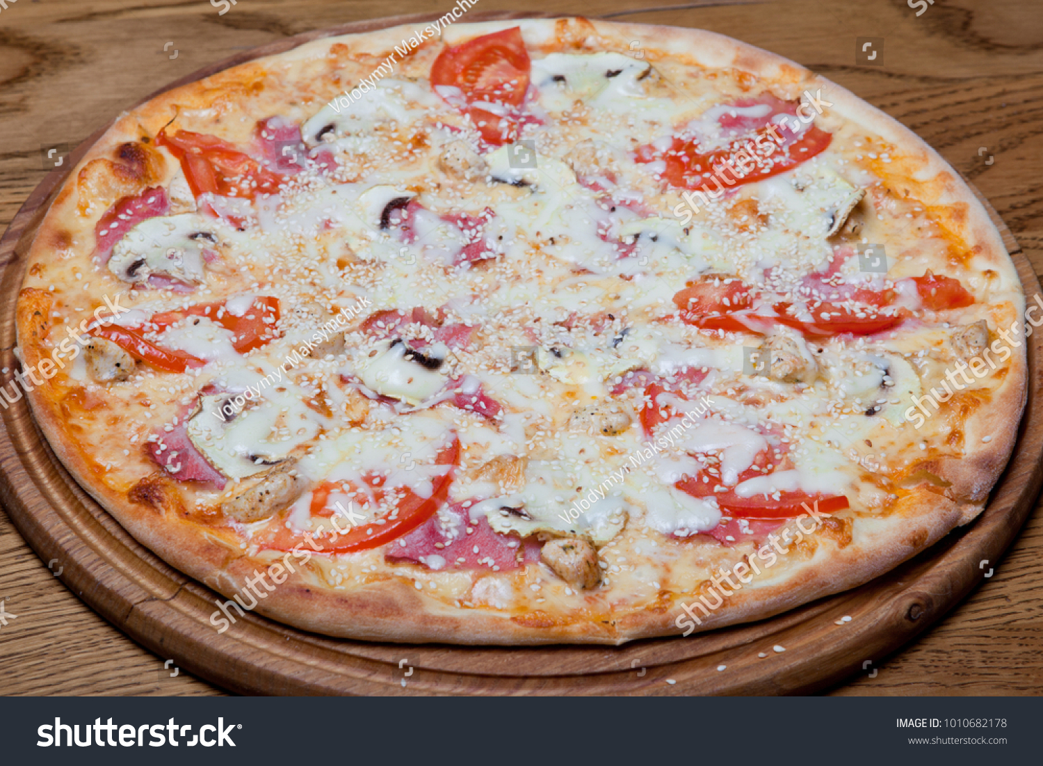 Pizza Milano on Pizza Milano creamy base, chicken fillet, mushrooms, tomatoes, mozzarella, sauce, oregano on a plate. plate #1010682178