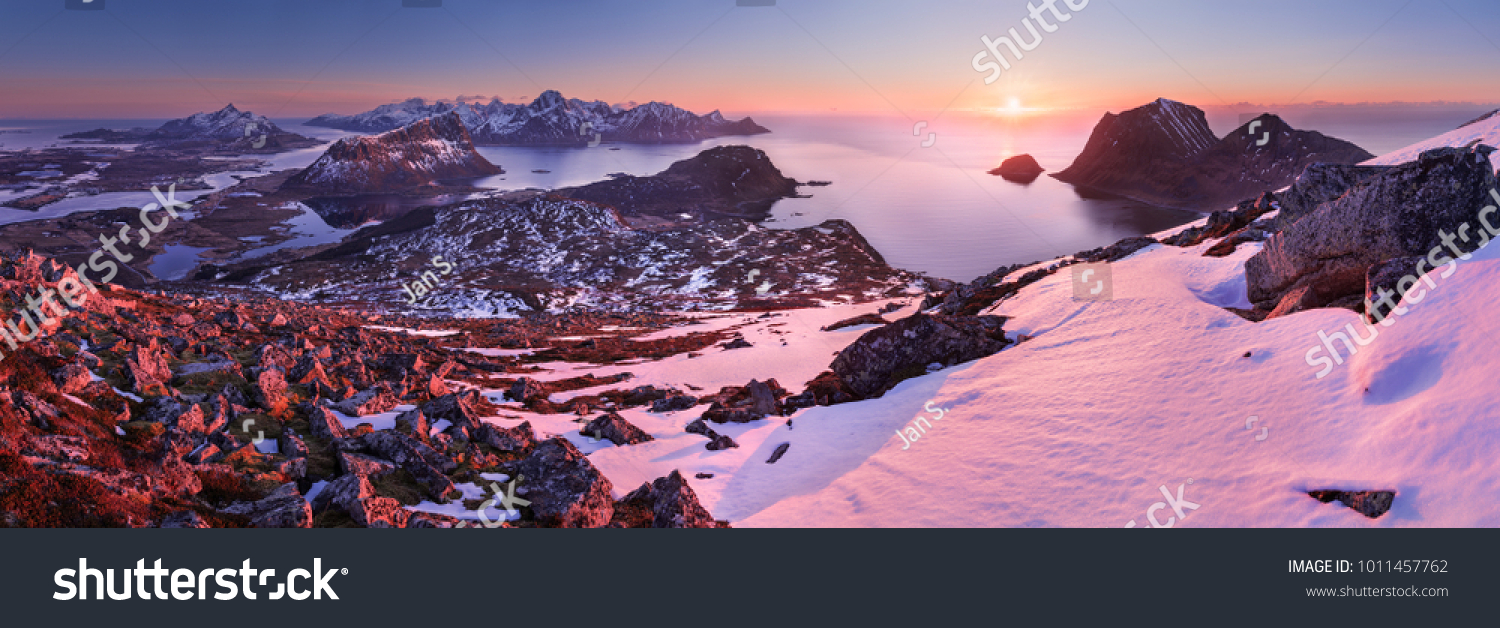 Horizontal panoramic photo of an aerial winter sunset taken at Norwegian Lofoten. Surrounding mountains, peaks, hills and islnads are clearly visible. #1011457762