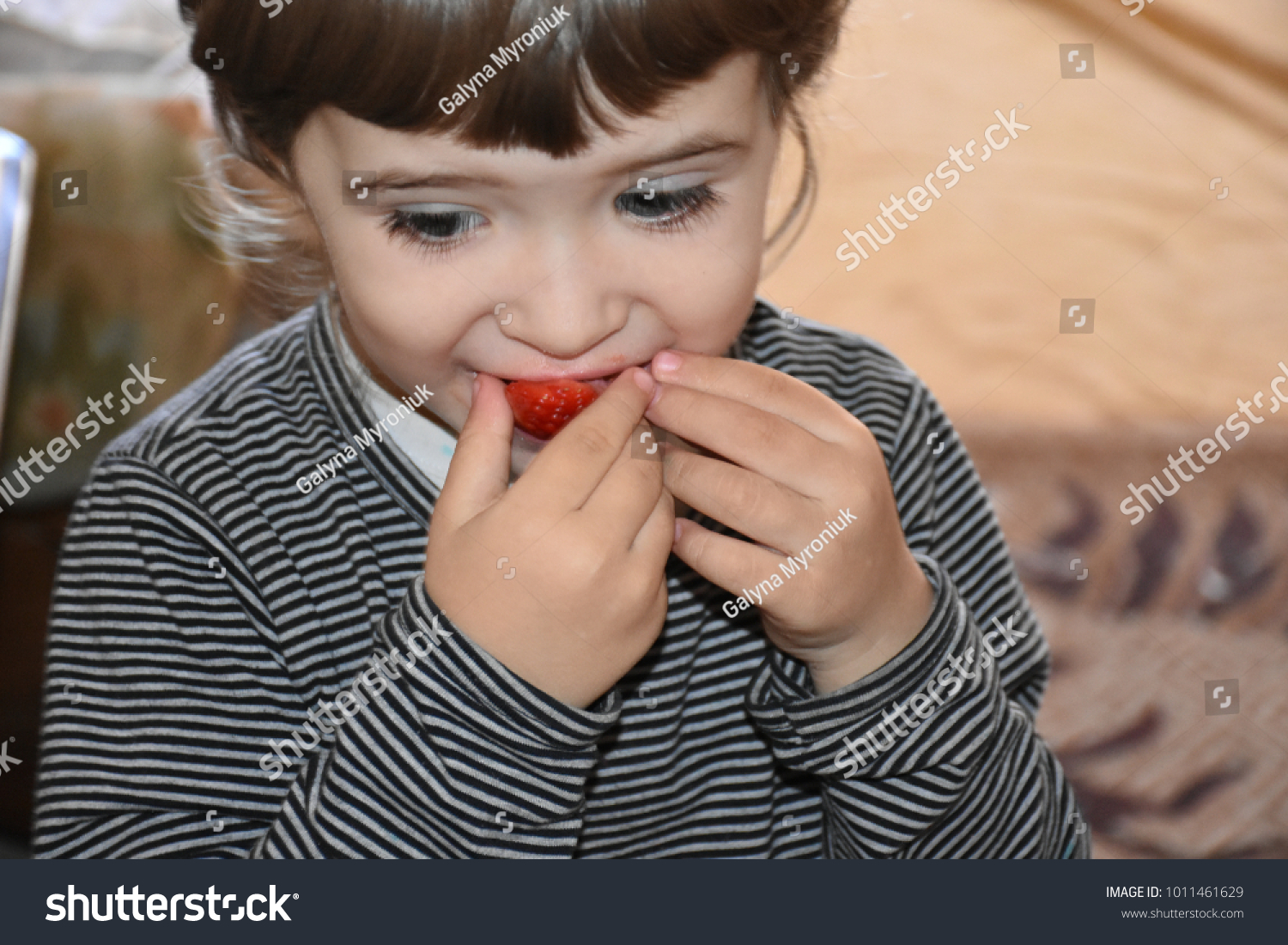 the child eats strawberries  #1011461629