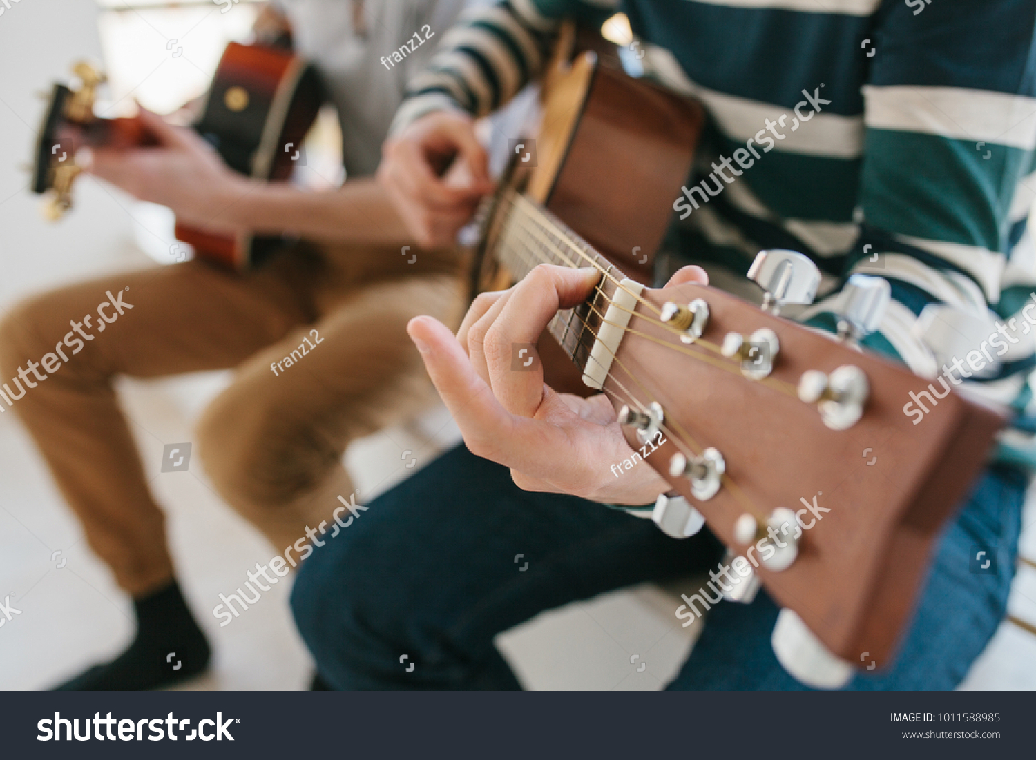 Learning to play the guitar. Music education and extracurricular lessons. Hobbies and enthusiasm for playing guitar and singing songs. #1011588985