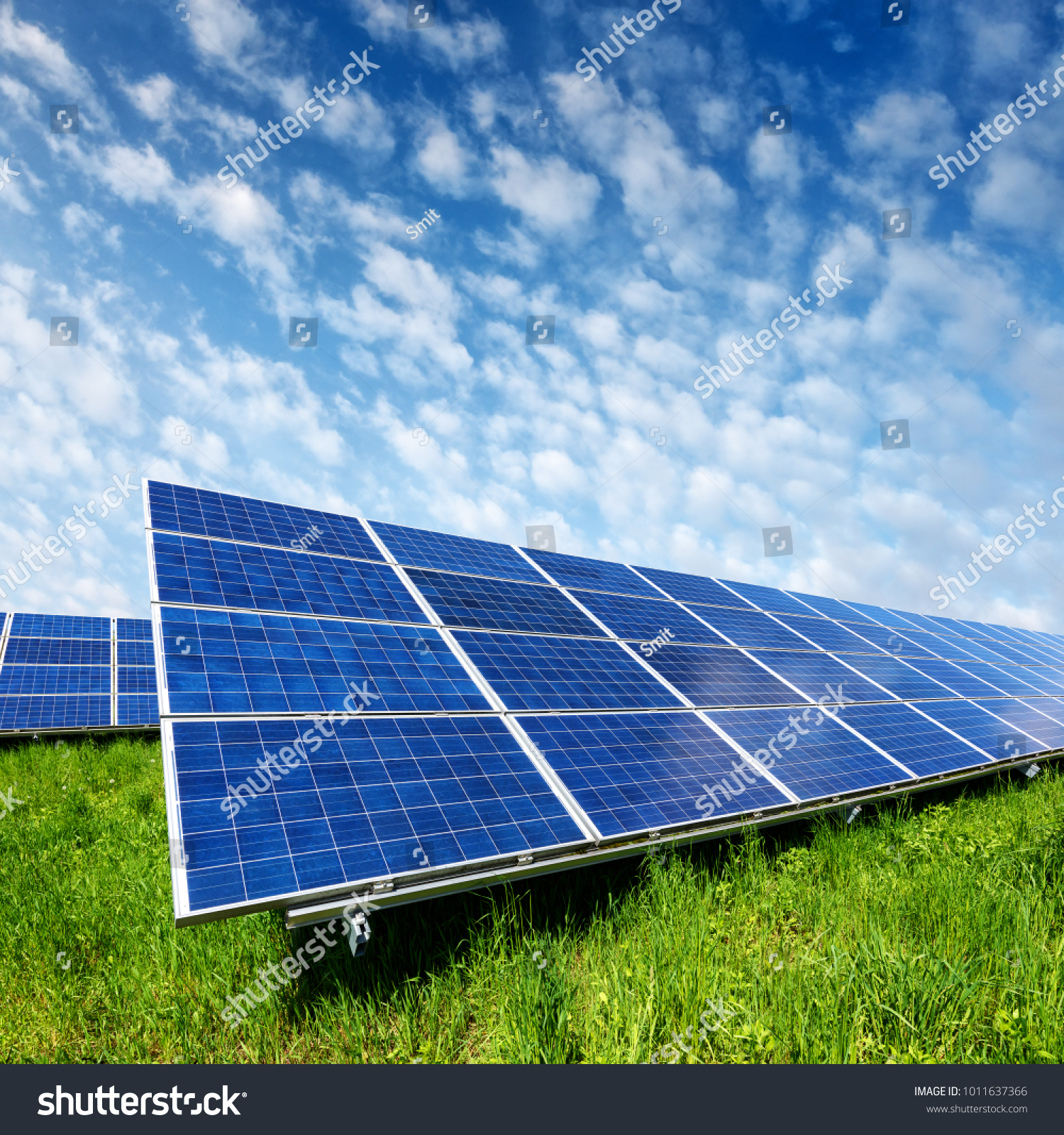 Solar panel on blue sky background. Green grass and cloudy sky. Alternative energy concept #1011637366