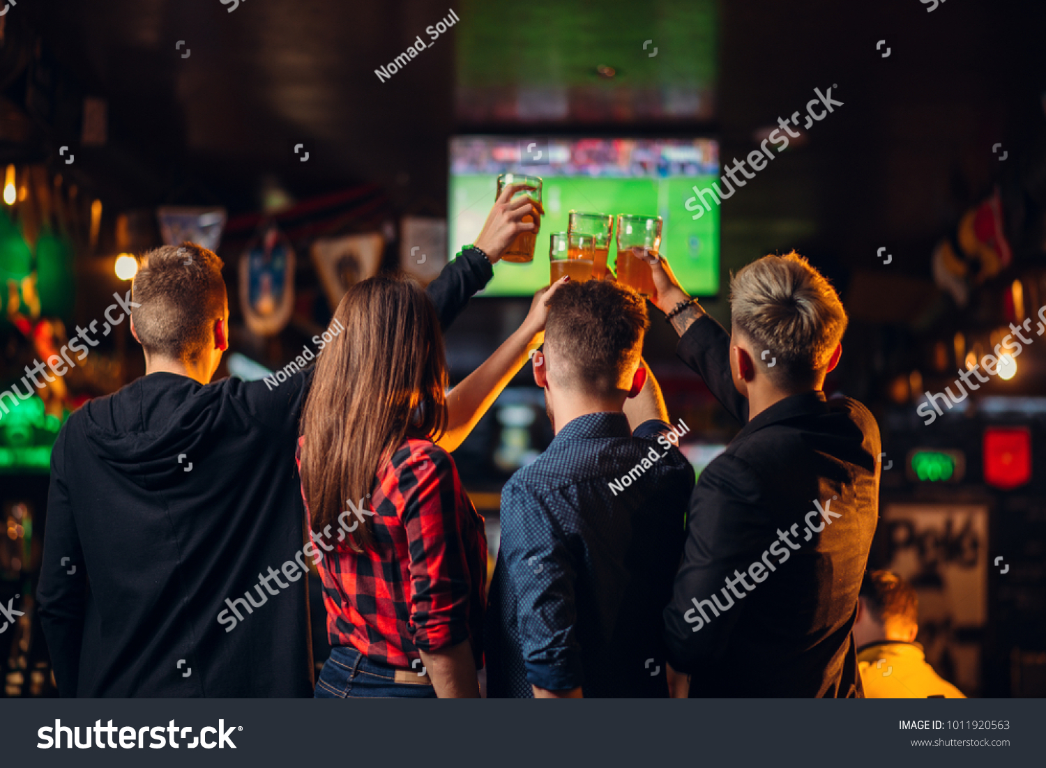 Friends watches football on TV in a sport bar #1011920563