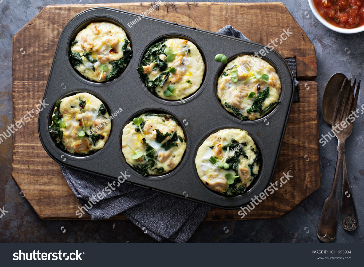 High protein egg muffins with kale and ground turkey in a muffin tin overhead shot #1011996934
