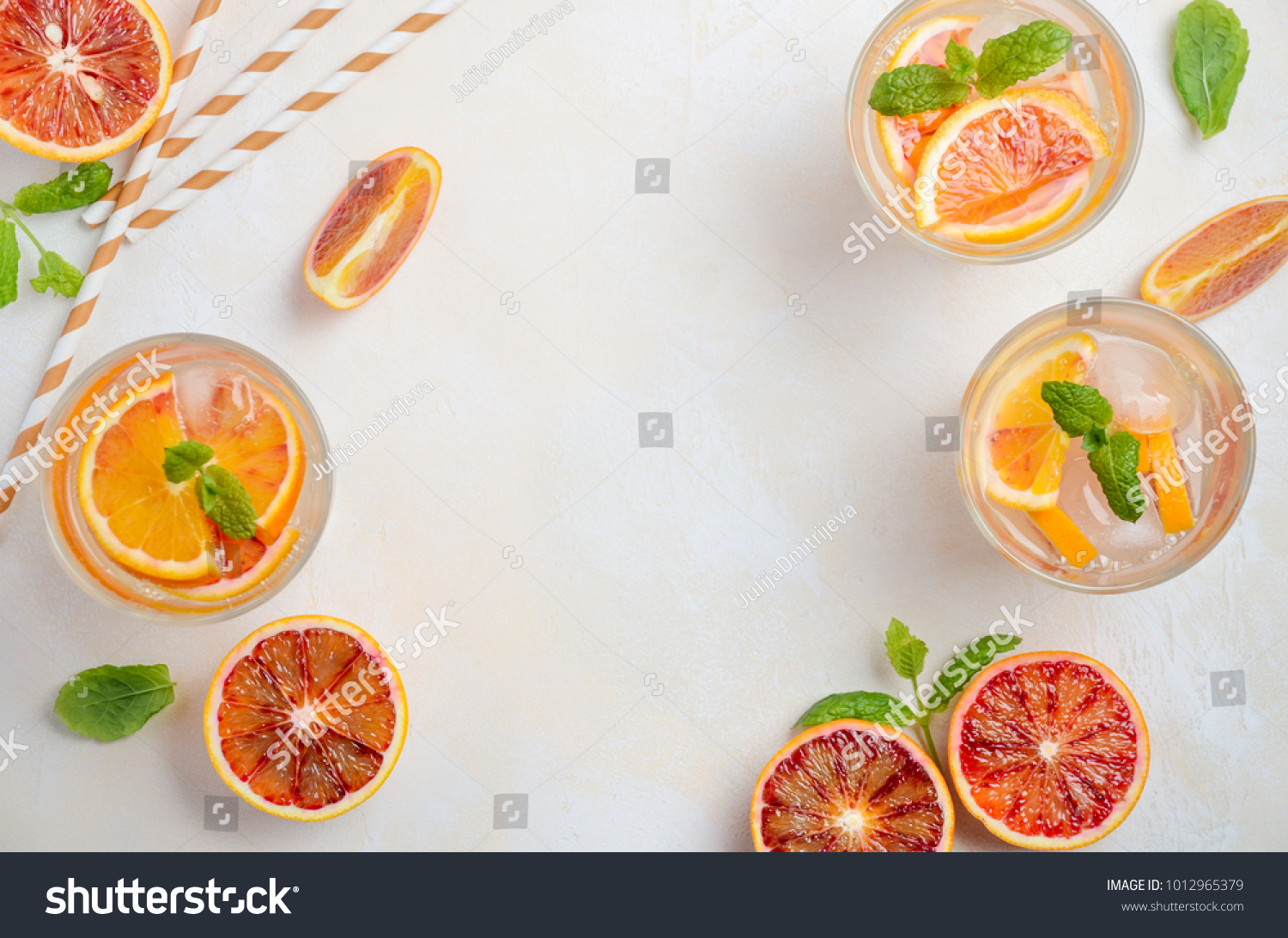 Summer lemonade. Cold refreshing drink with blood orange slices in a glass on a white concrete background. Top view, flat lay, copy space. #1012965379