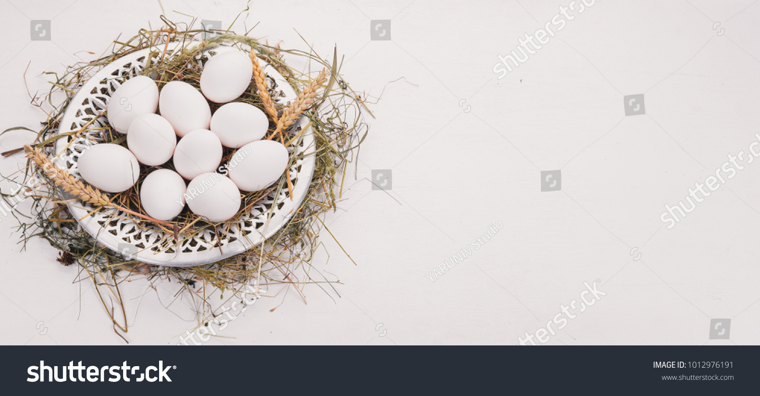 Chicken raw eggs on a metal plate. On a wooden background. Top view. Copy space. #1012976191