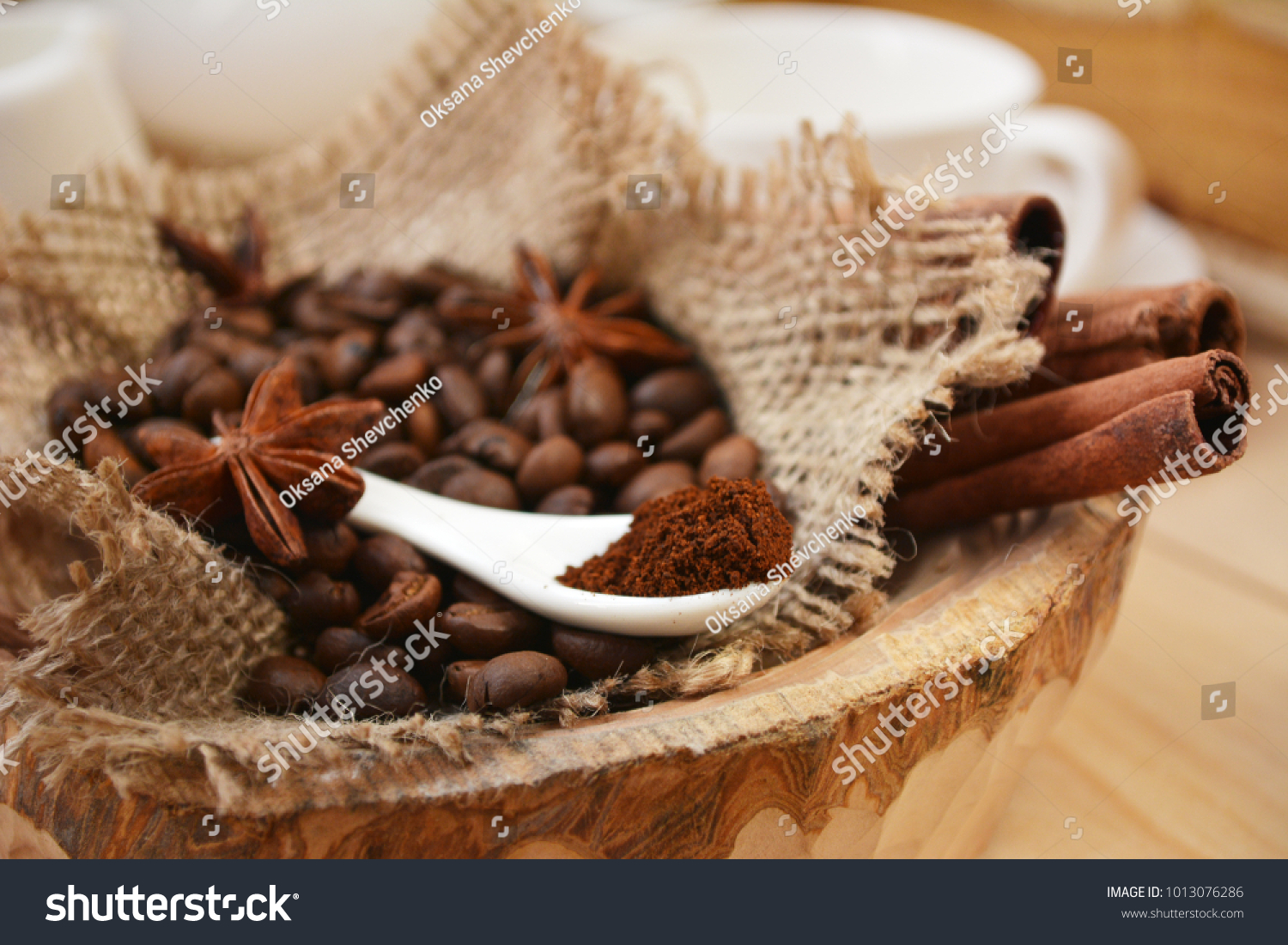 grated coffee in white porcelain spoon on blurred  roasted coffee beans background. aroma coffee ingredients. selective focus. #1013076286