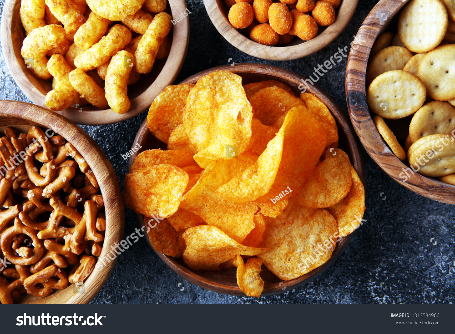 Salty snacks. Pretzels, chips, crackers in wooden bowls. #1013584966