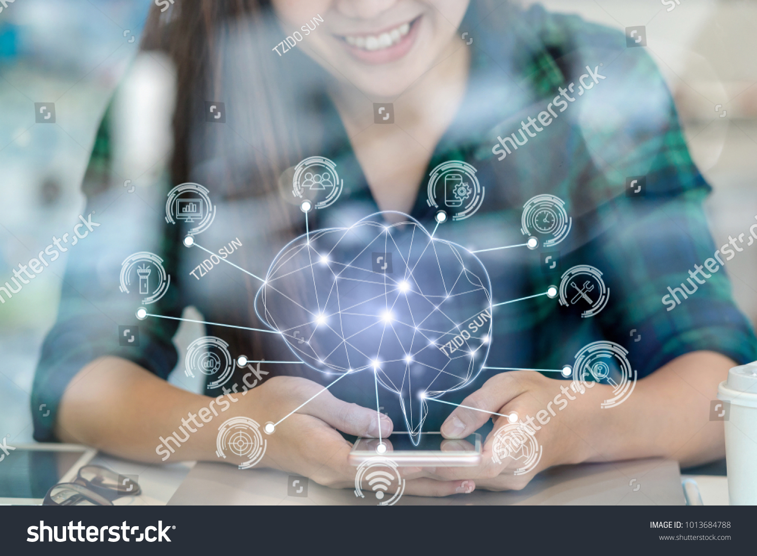 Polygonal brain shape of an artificial intelligence with various icon of smart city Internet of Things Technology over Asian businesswoman hand using the smart mobile phone,AI and business IOT concept #1013684788
