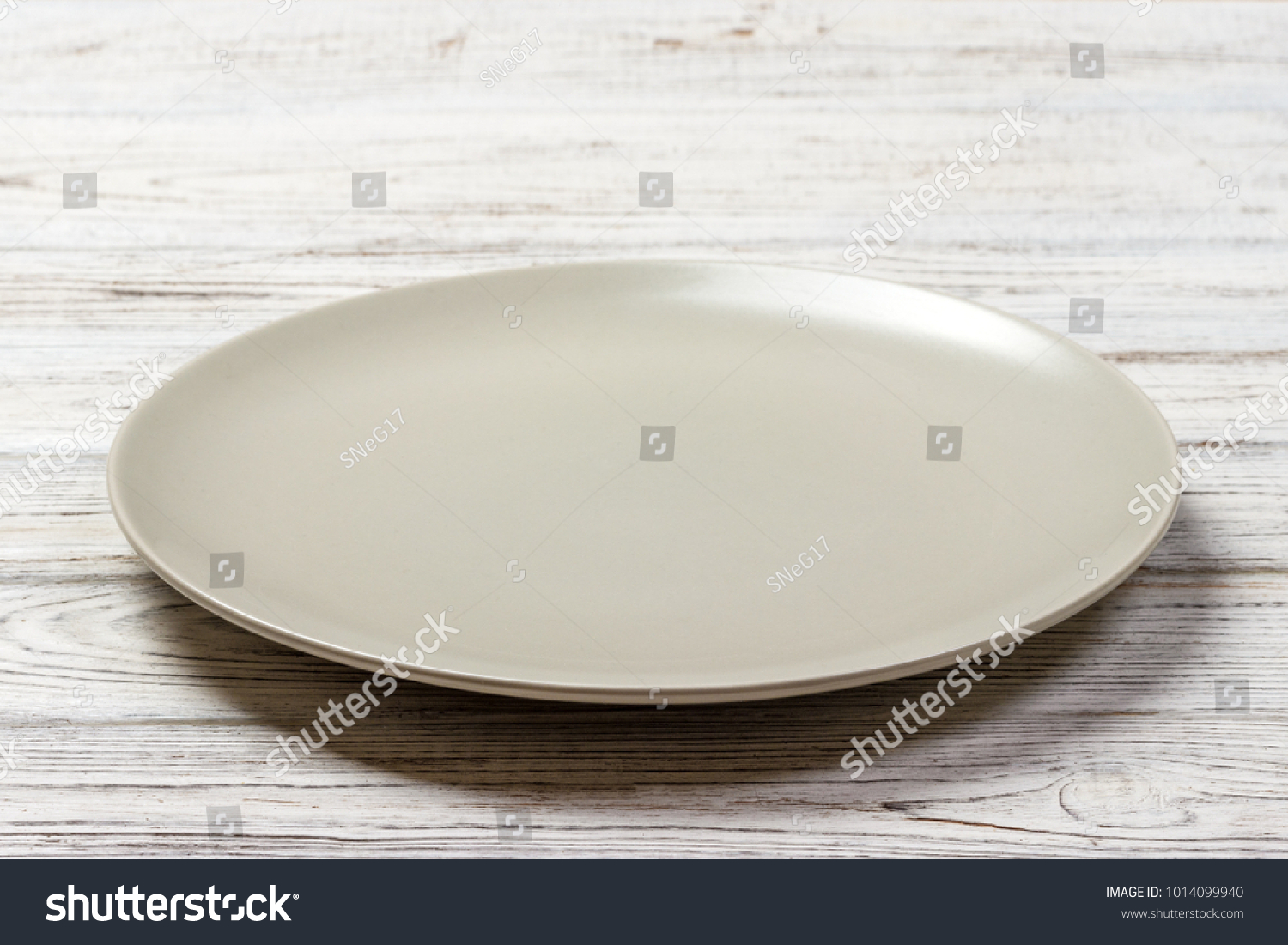 Perspective view. Empty white plate on wooden background. #1014099940