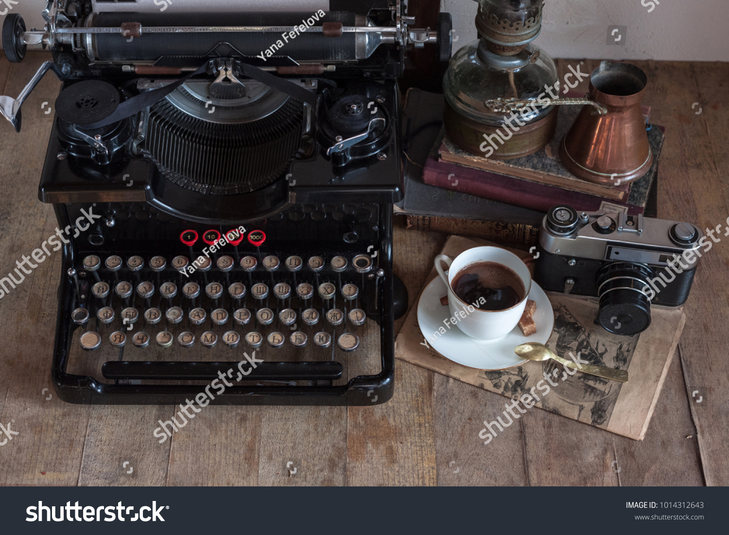 Old retro journalist typewriter with cup of coffee, copper jug, gas lamp, books, newspaper, typewritter on wooden rustic background. #1014312643