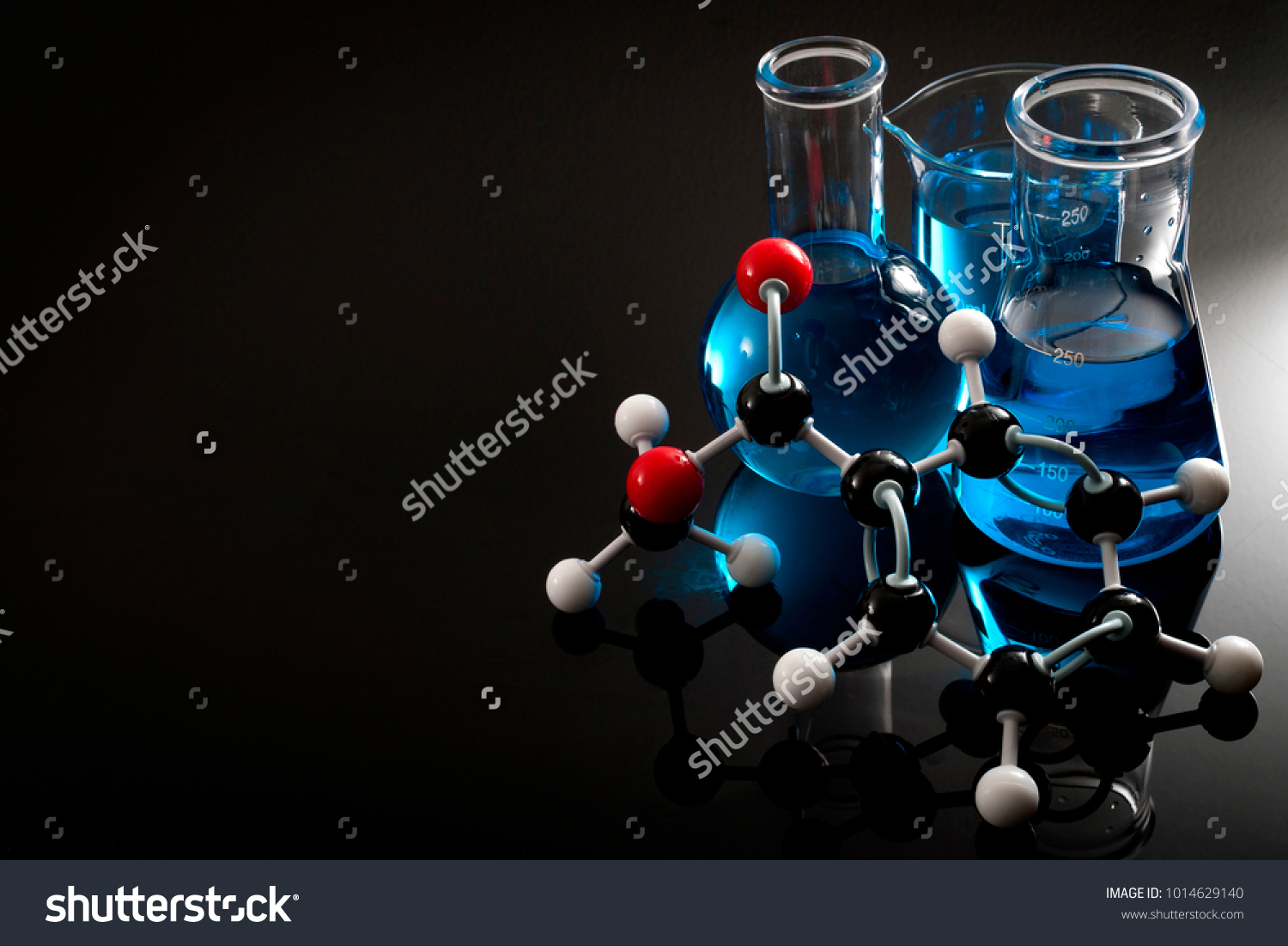 Organic chemistry, science class and STEM research concept with a methyl benzoate molecule on blue chemical solution in chemistry glassware, Erlenmeyer and Boiling (or Florence) flasks with copy space #1014629140