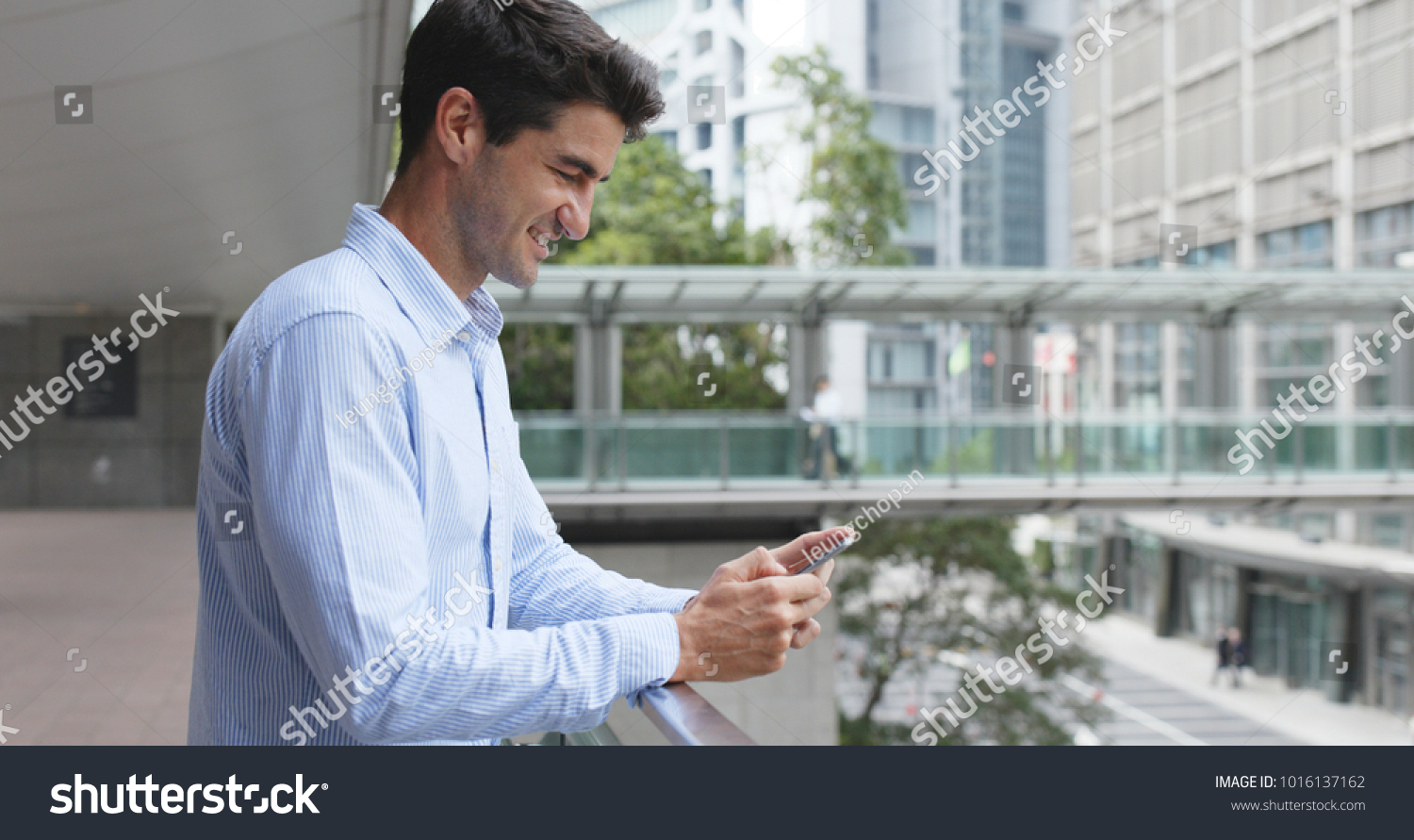 Businessman use of cellphone in Hong Kong city  #1016137162