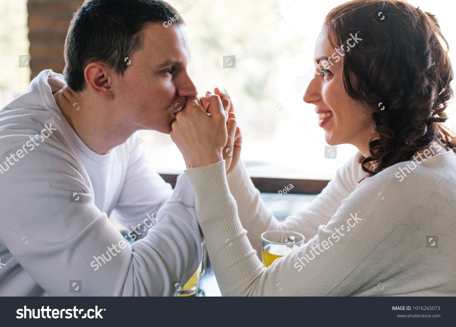 Young man kissing girlfriend's hands. Couple in love #1016265073