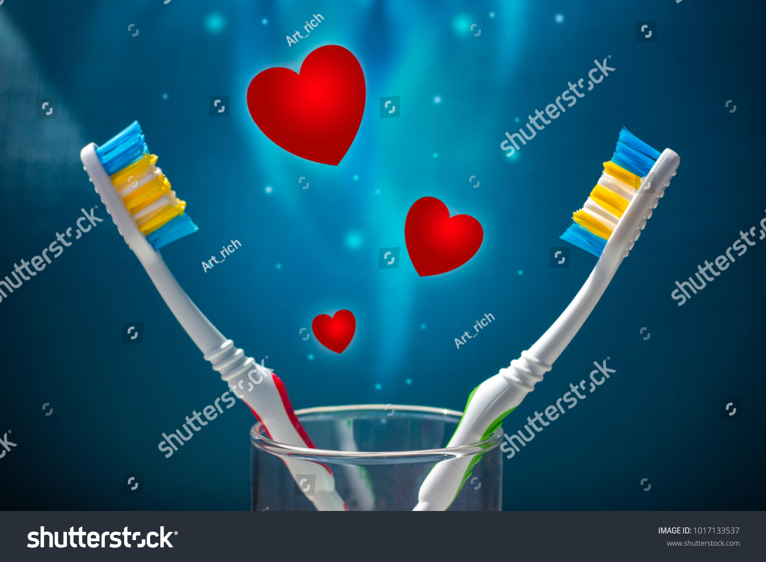 Two toothbrushes on a blue background and a lot of red hearts. Love and Valentine's Day. Copy space #1017133537