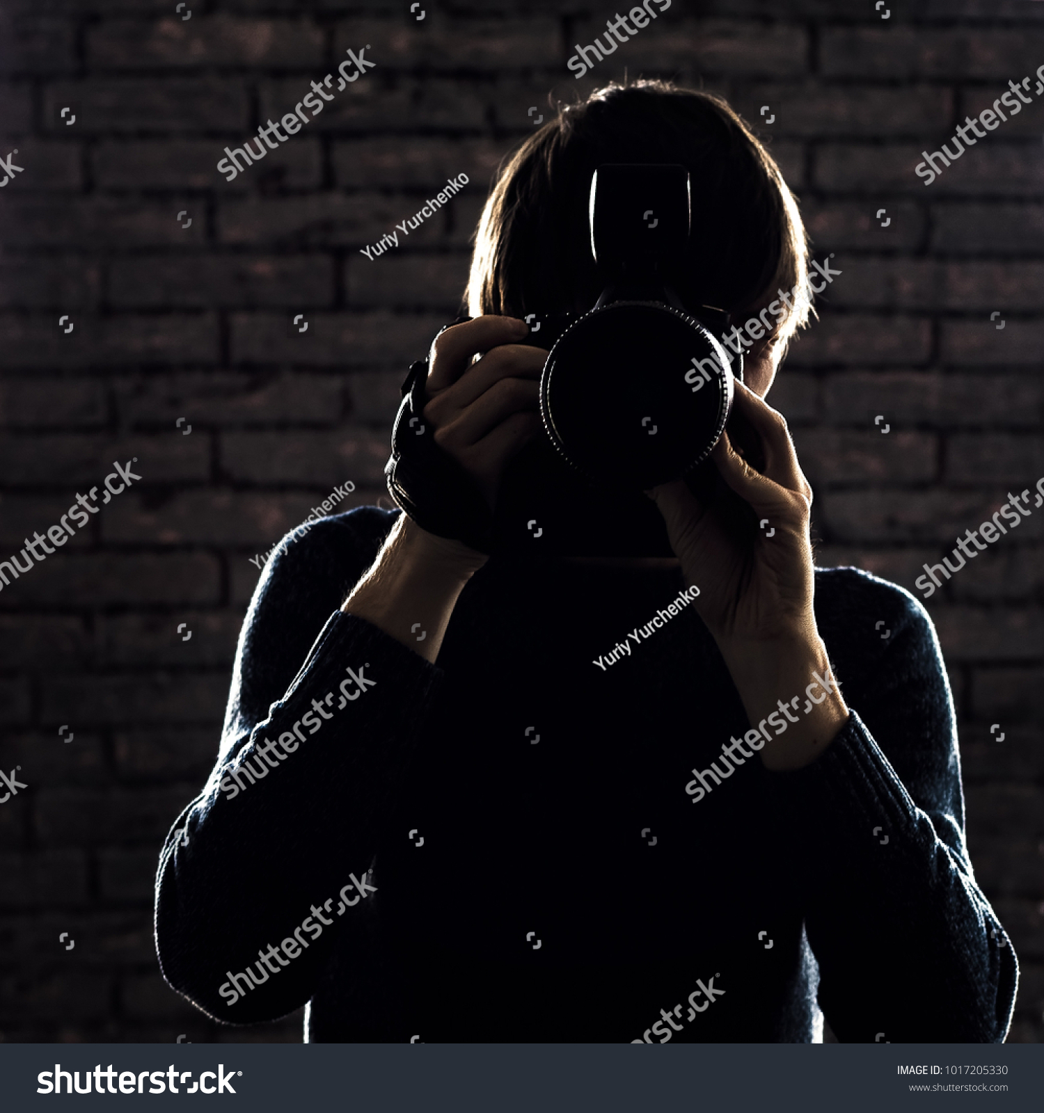 Silhouette of Photographer on brick wall background #1017205330