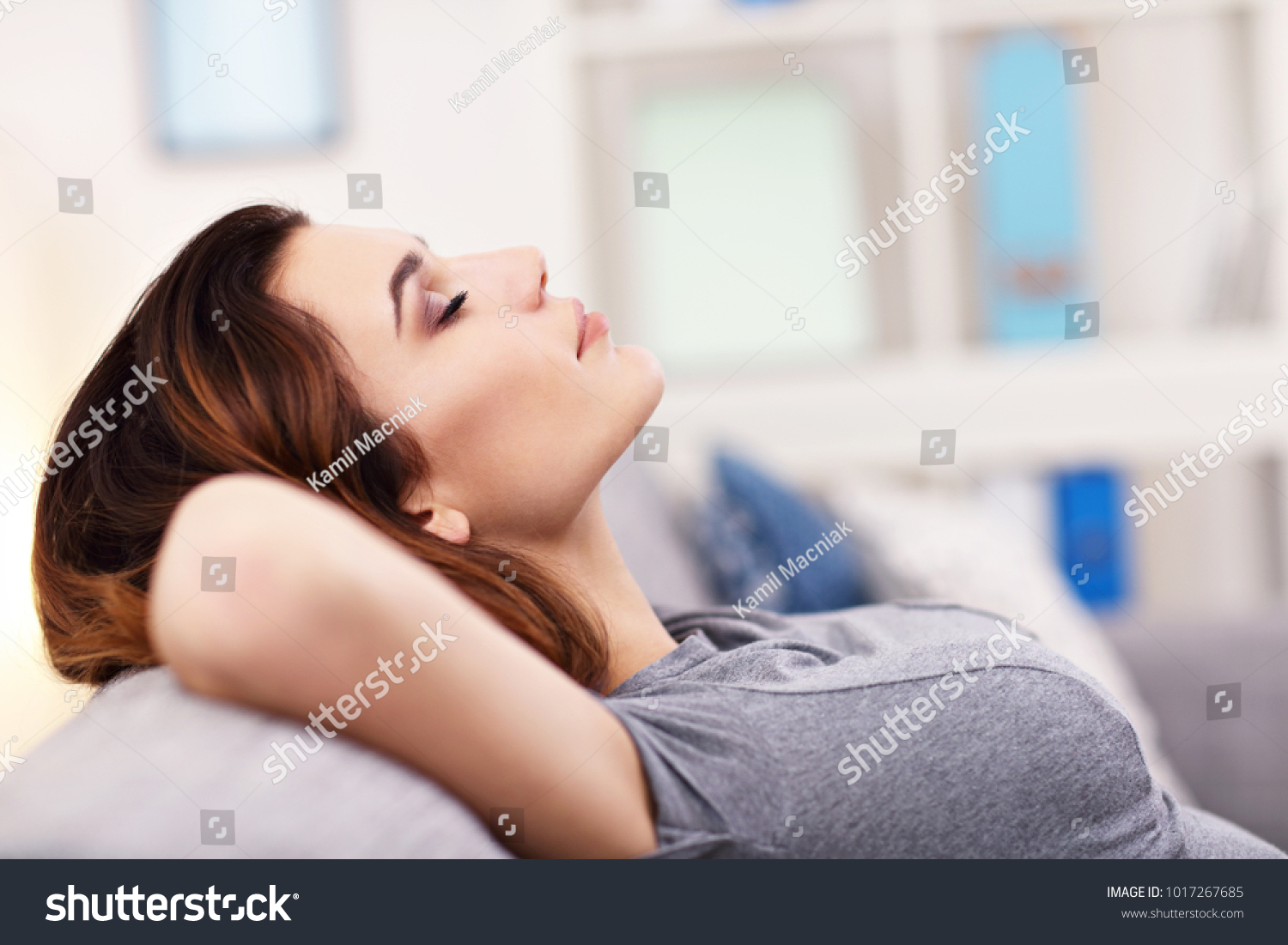 Picture of relaxed young woman enjoying rest on comfortable sofa #1017267685