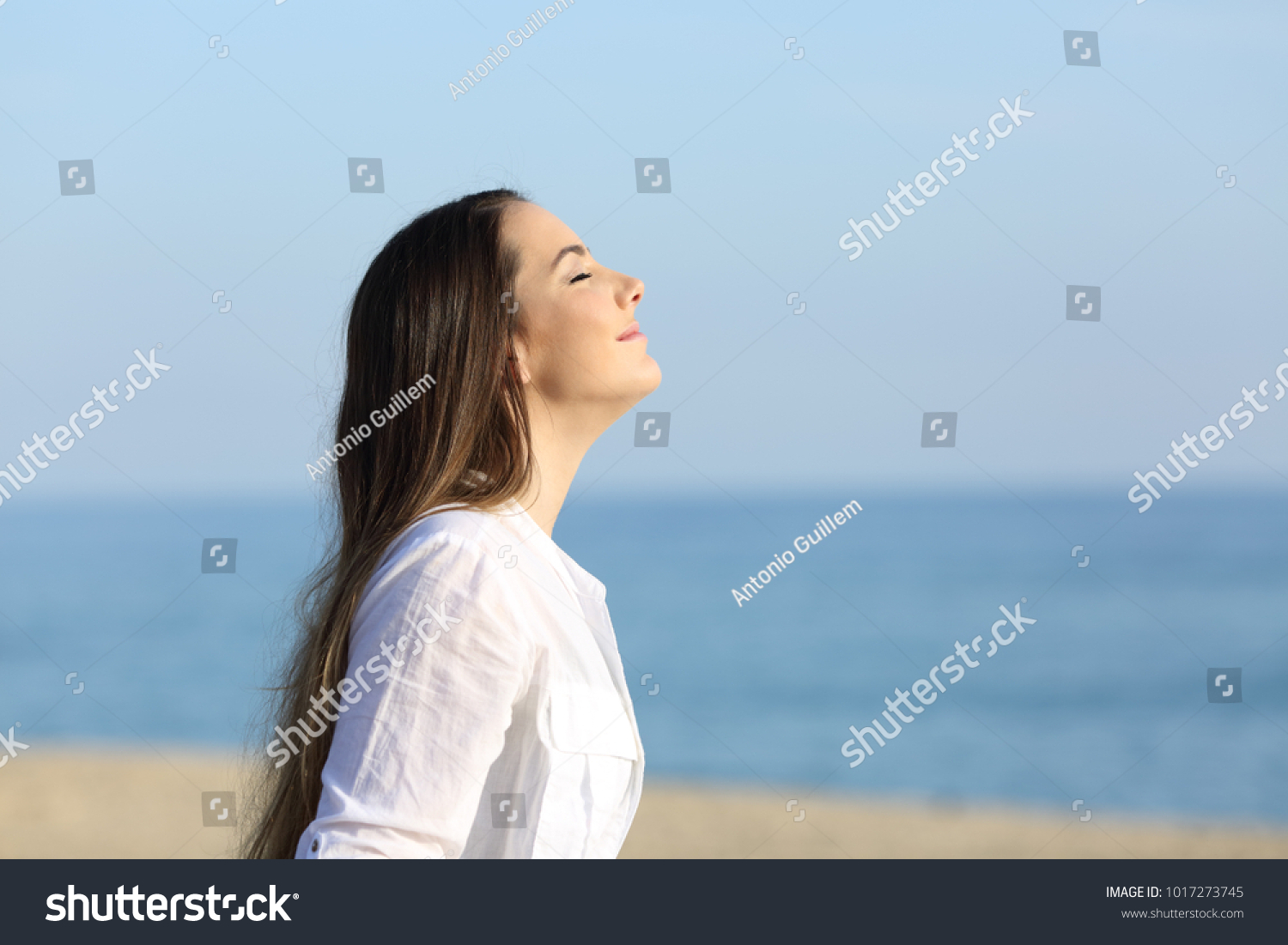 Side view portrait of a woman relaxing breathing fresh air on the beach #1017273745