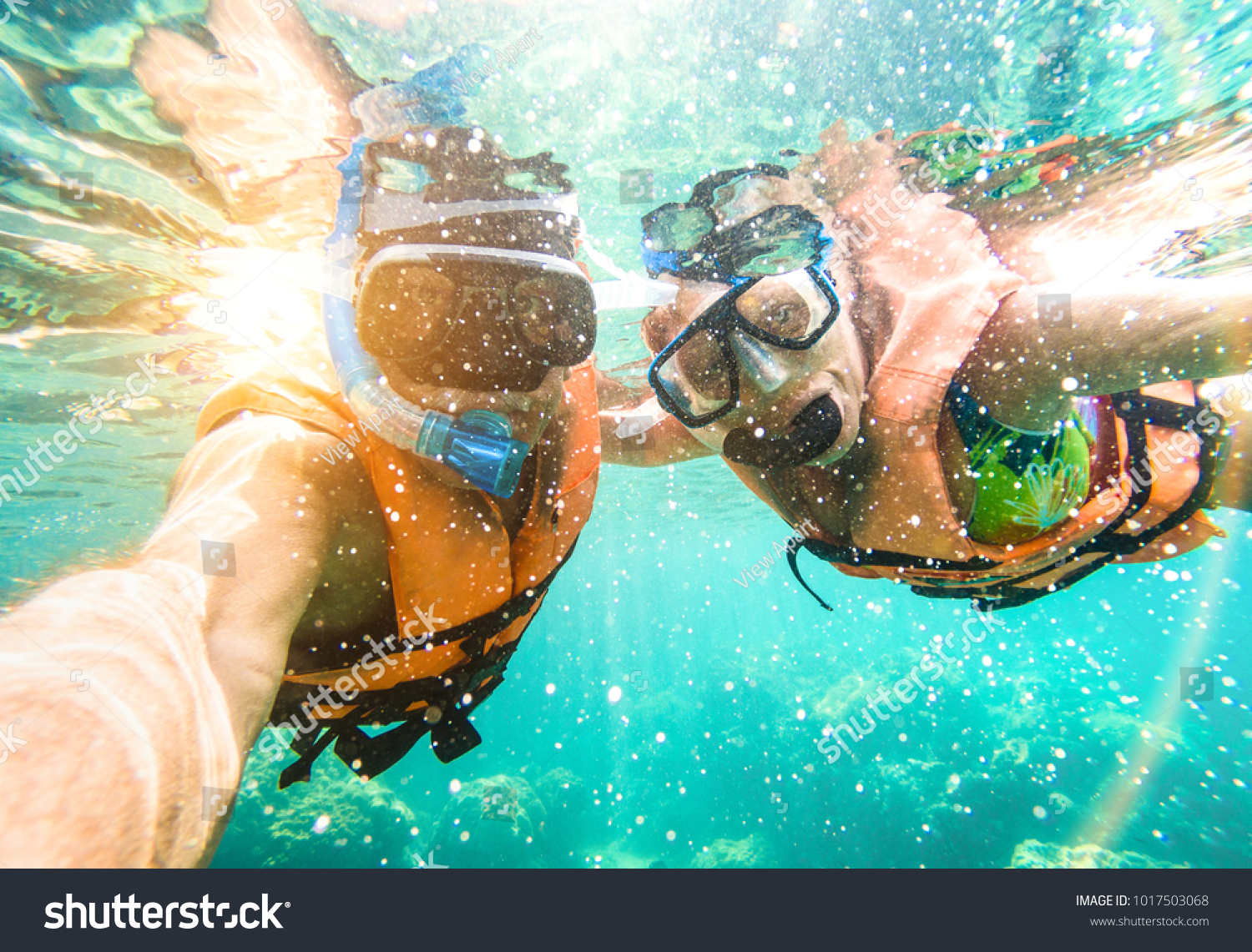 Senior happy couple taking selfie in tropical sea excursion with water camera - Boat trip snorkeling in exotic scenarios - Active retired elderly and fun concept on scuba diving - Warm vivid filter #1017503068