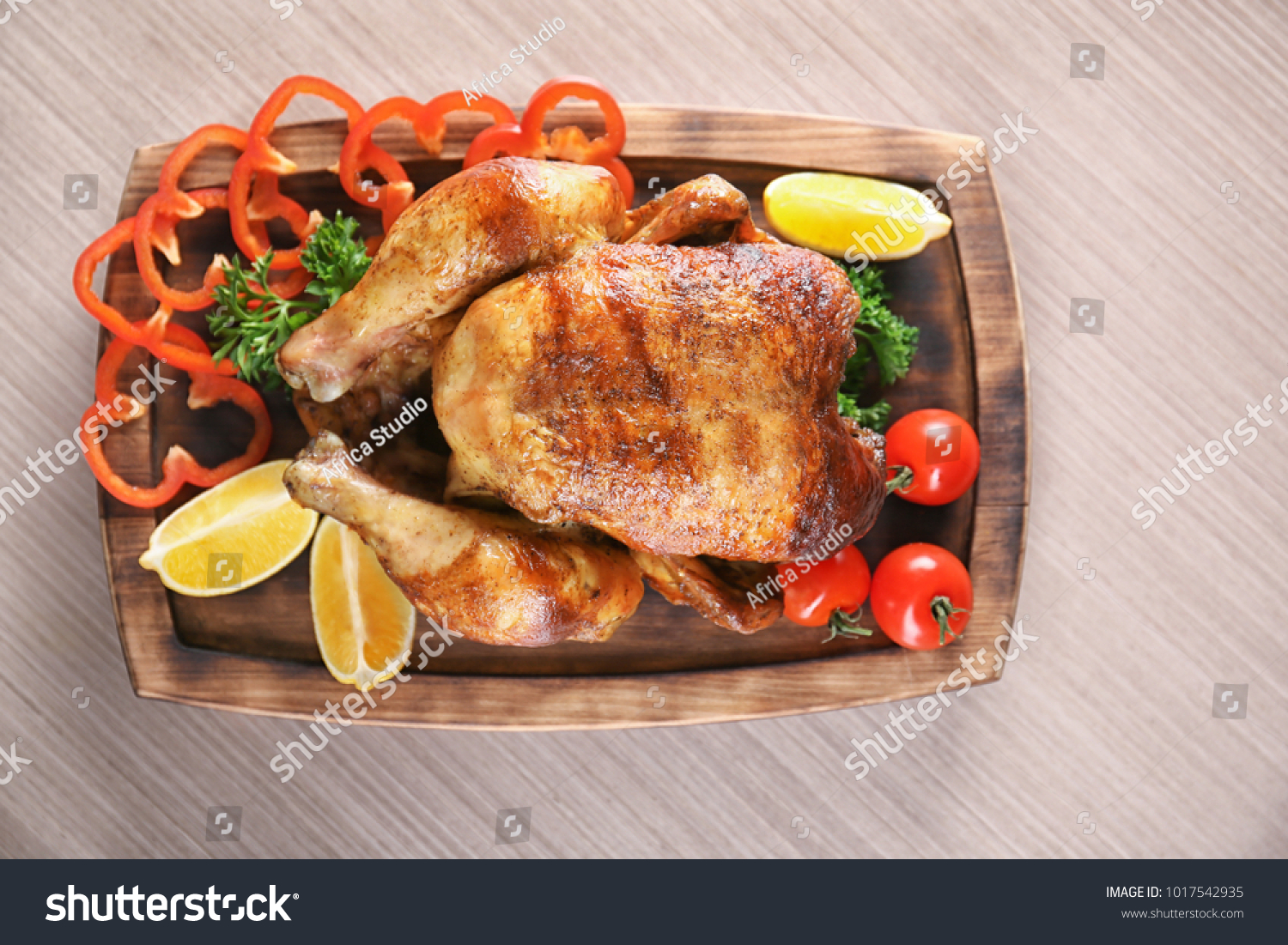 Delicious whole roasted chicken with vegetables served on wooden board #1017542935