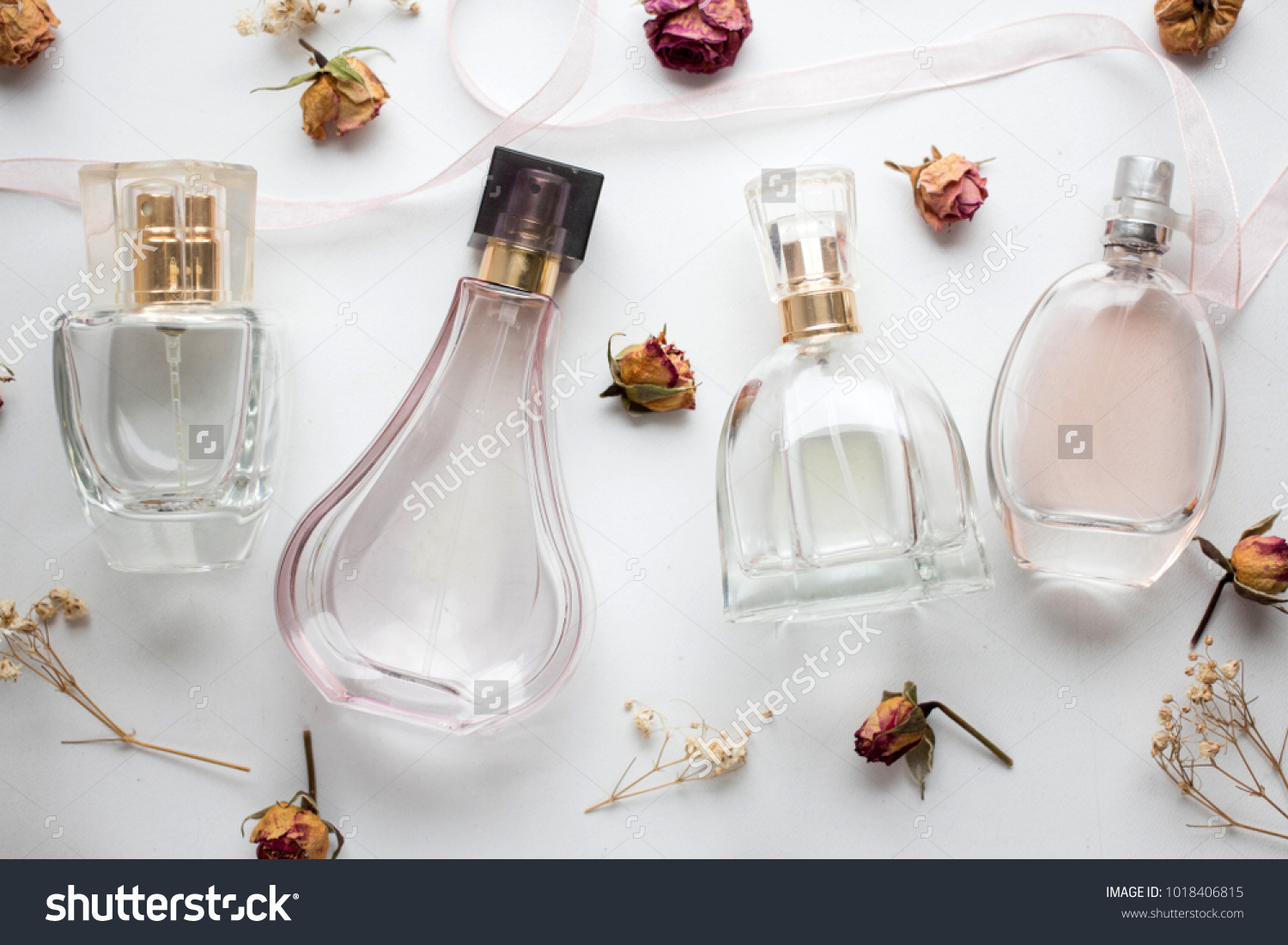 bottle of woman perfume on white background with roses. gift. #1018406815