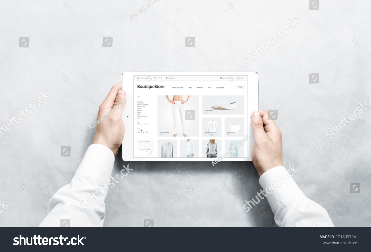 Hands holding tablet with fashion webstore mock up on screen, isolated. Clothing web page interface mockup. Internet website online template on the device display. #1018997941