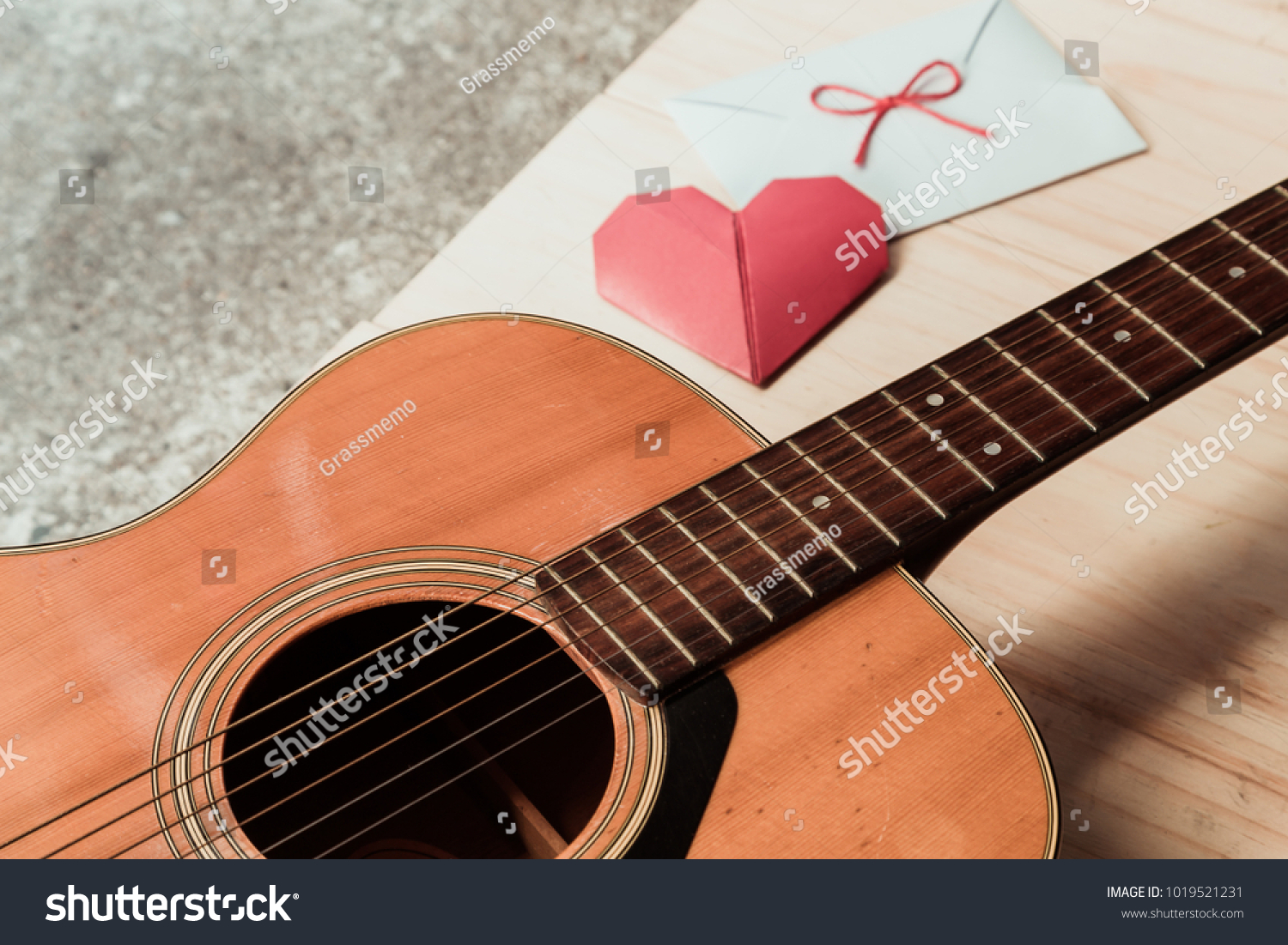 The guitar and red heart fold paper with white envelope. Long distance relationship and love song as a concept. #1019521231