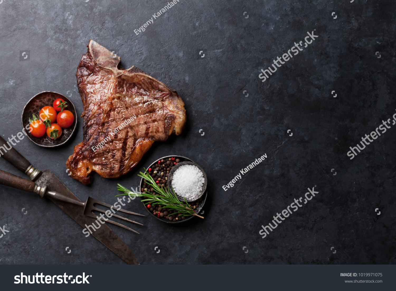 Grilled T-bone steak on stone table. Top view with copy space #1019971075