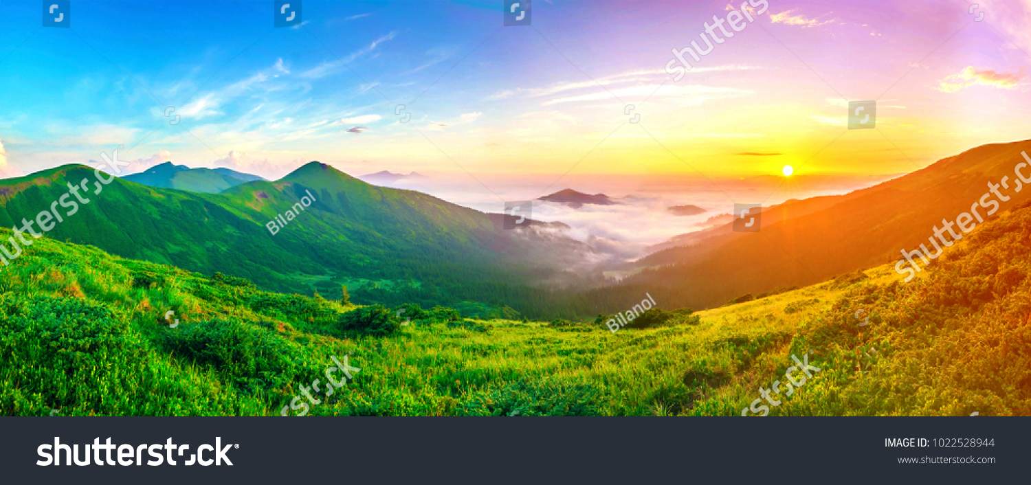 Beautiful sunrise in mountains with white fog below panorama #1022528944