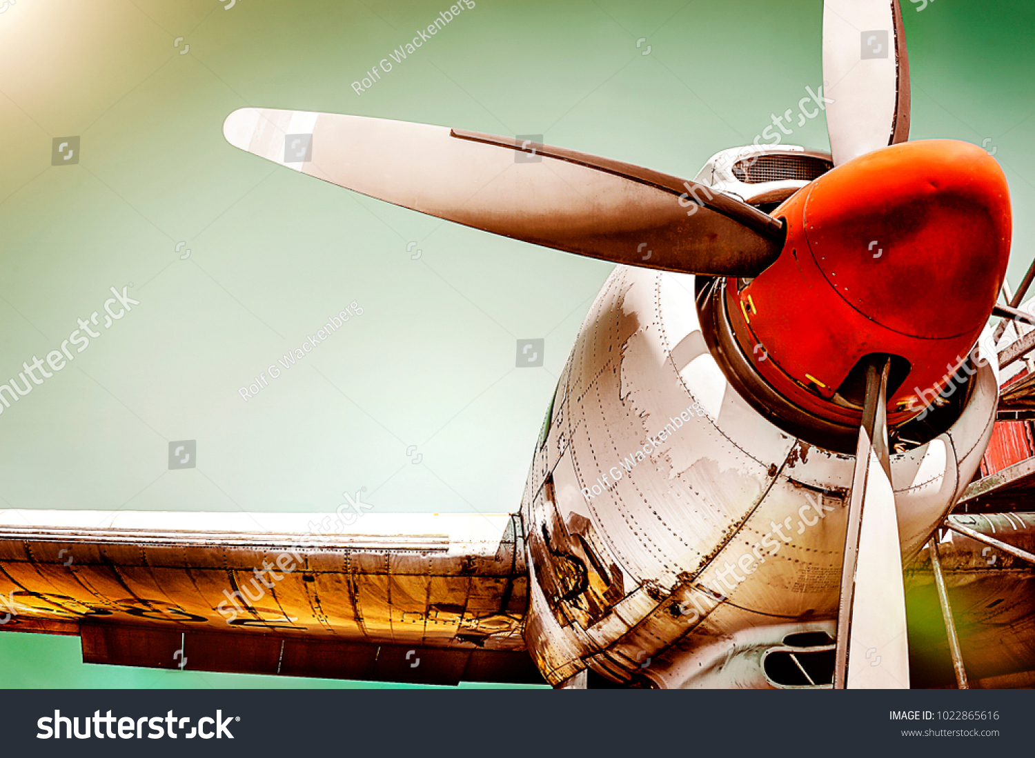 Old airplane turboprop engine with propeller blades, parts of wings and aircraft fuselage - concept closeup  historic vintage plane travel flight dramatic look retro style propeller plane aircraft #1022865616