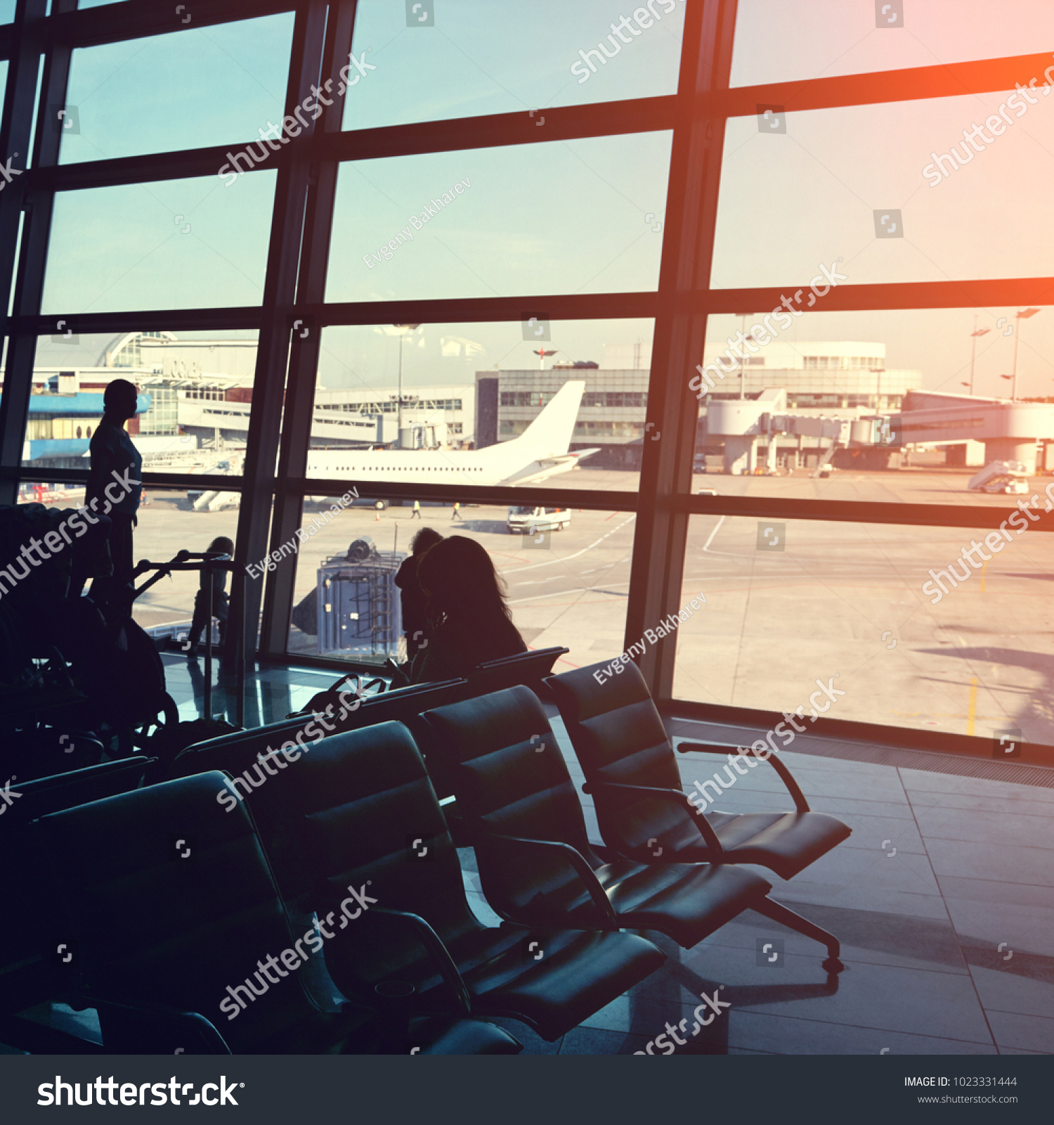 silhouette of a group of people in an airport waiting hall. travel business concept #1023331444