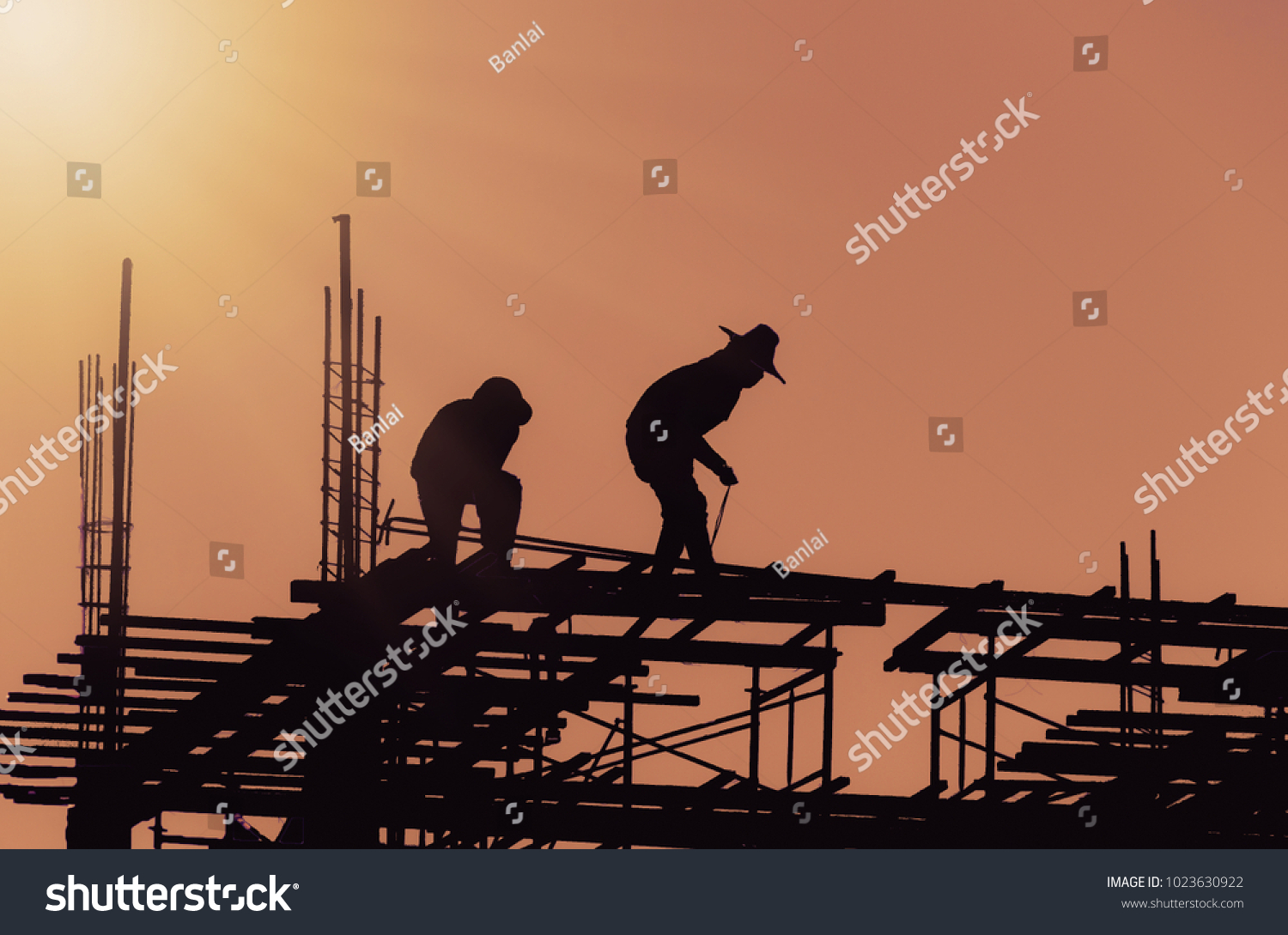 Silhouette City worker, construction crews to work on high ground heavy industry and safety concept over blurred natural background sunset  #1023630922