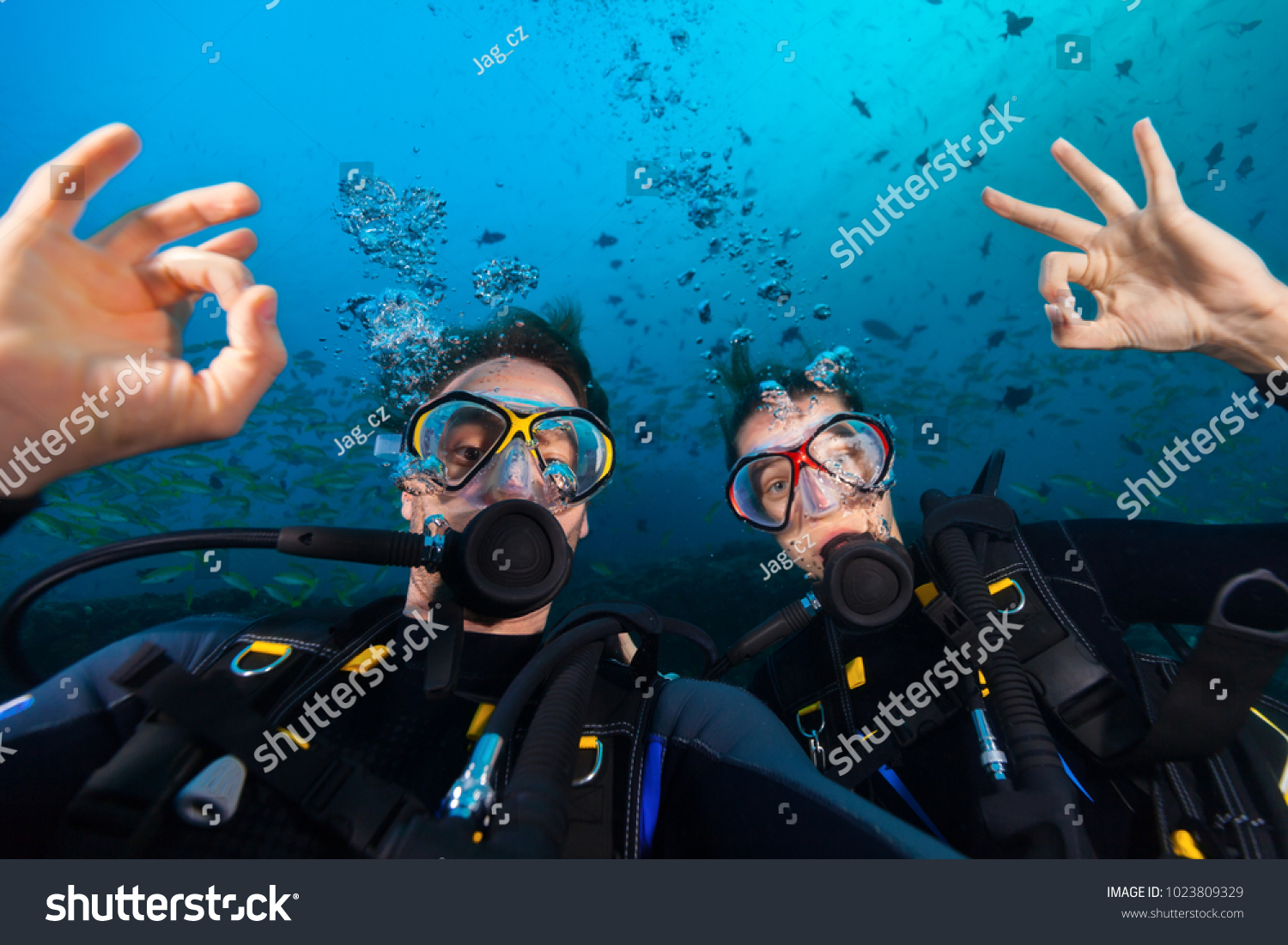 Couple of scuba divers showing ok sign, portrait photography. Underwater sports and activities #1023809329