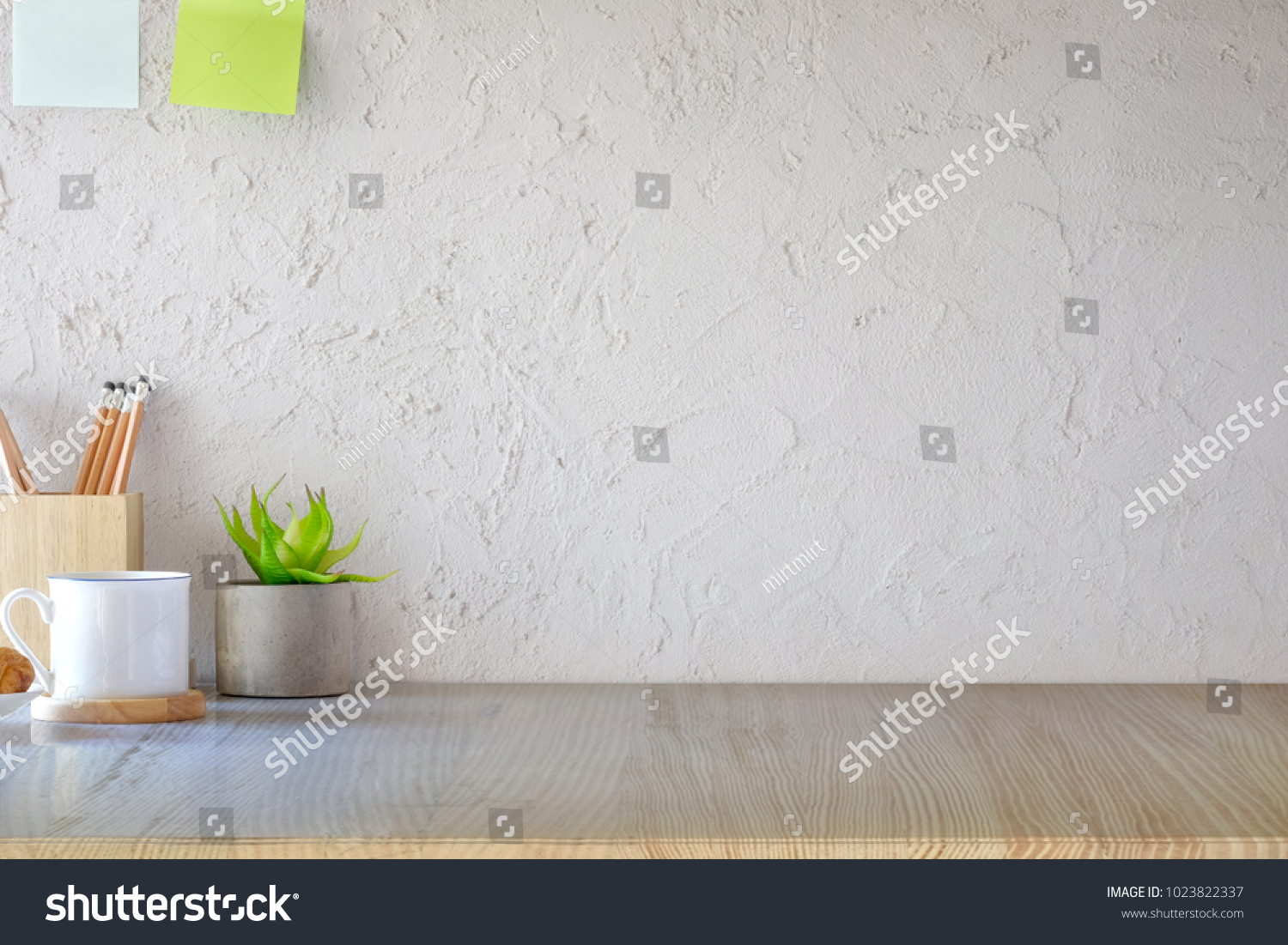 Front view of wood desk with coffee mug and house plant. workspace and copy space #1023822337
