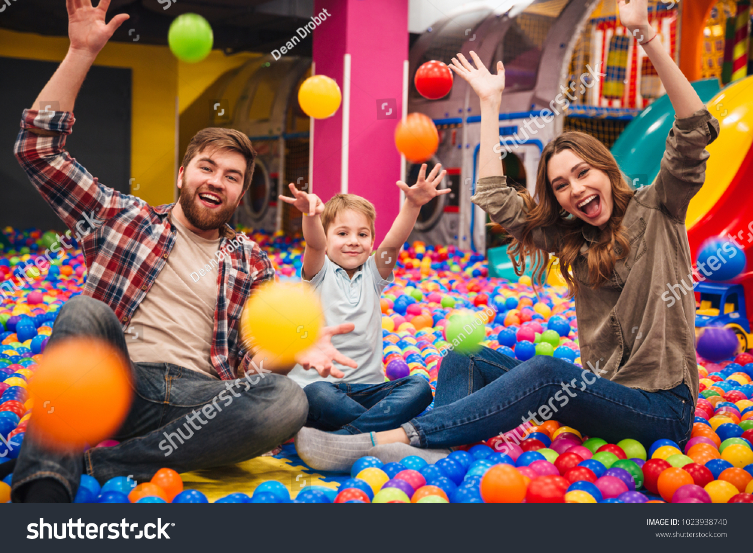 Image of emotional cheerful little child have fun with his parents in entertainment game center. #1023938740