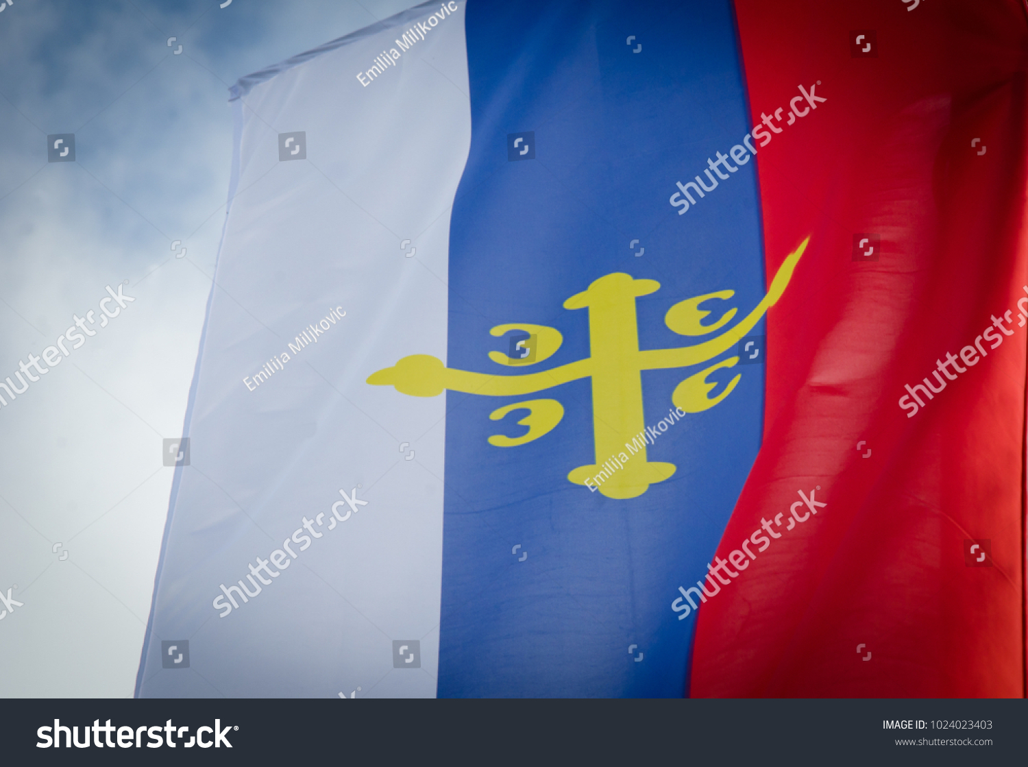 flag of the Serbian orthodox church close up with cloudy blue sky  #1024023403