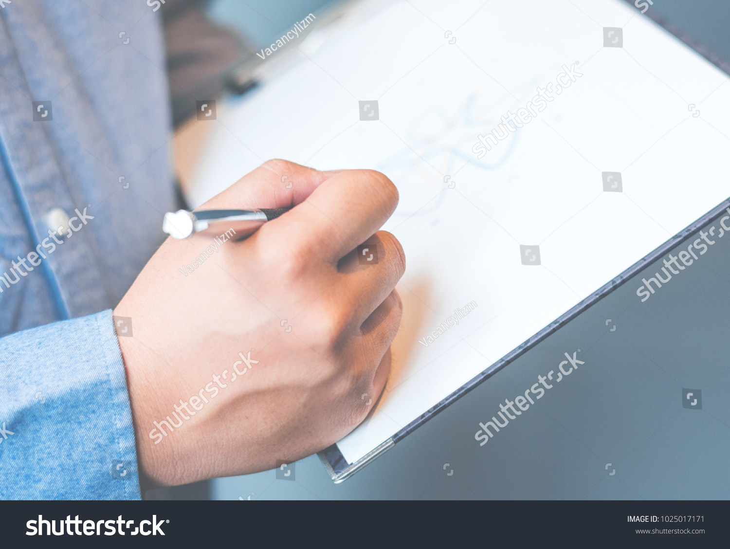 Photo business man wearing suit, looking smartphone and holding documents in hands. Open space loft office,young business man reading sitting at the desk on office background #1025017171