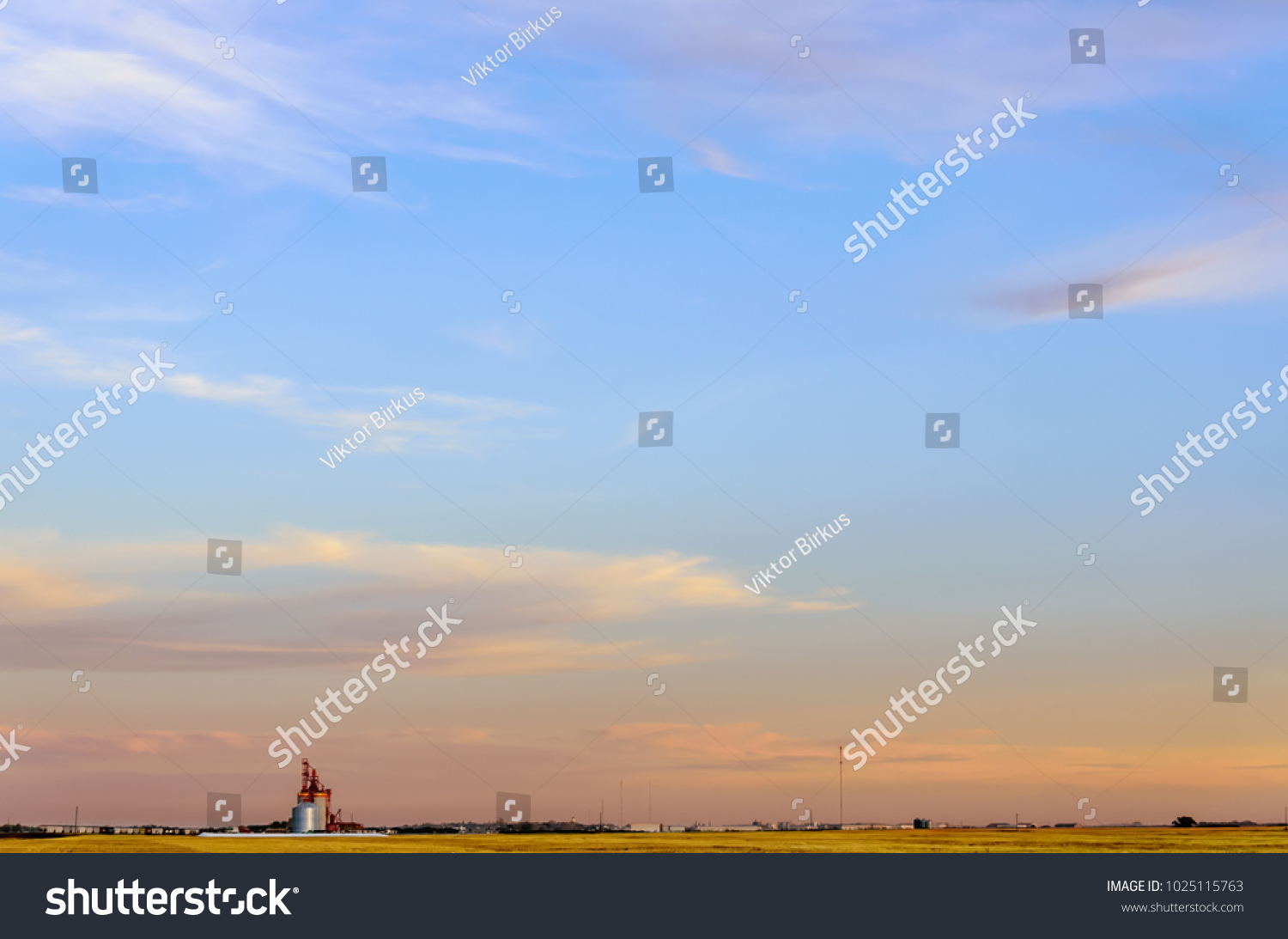 multicolored, fluffy tender cirrus clouds, yellow field, elevator and silver barns for grain, timber, freight cars, white tower, radio and body towers, white buildings #1025115763