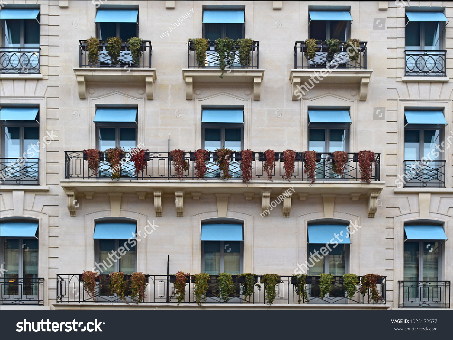 The beautiful style of balconies and windows with flowers hanging, look retro . Concept Vintage balcony in Paris, France.  #1025172577