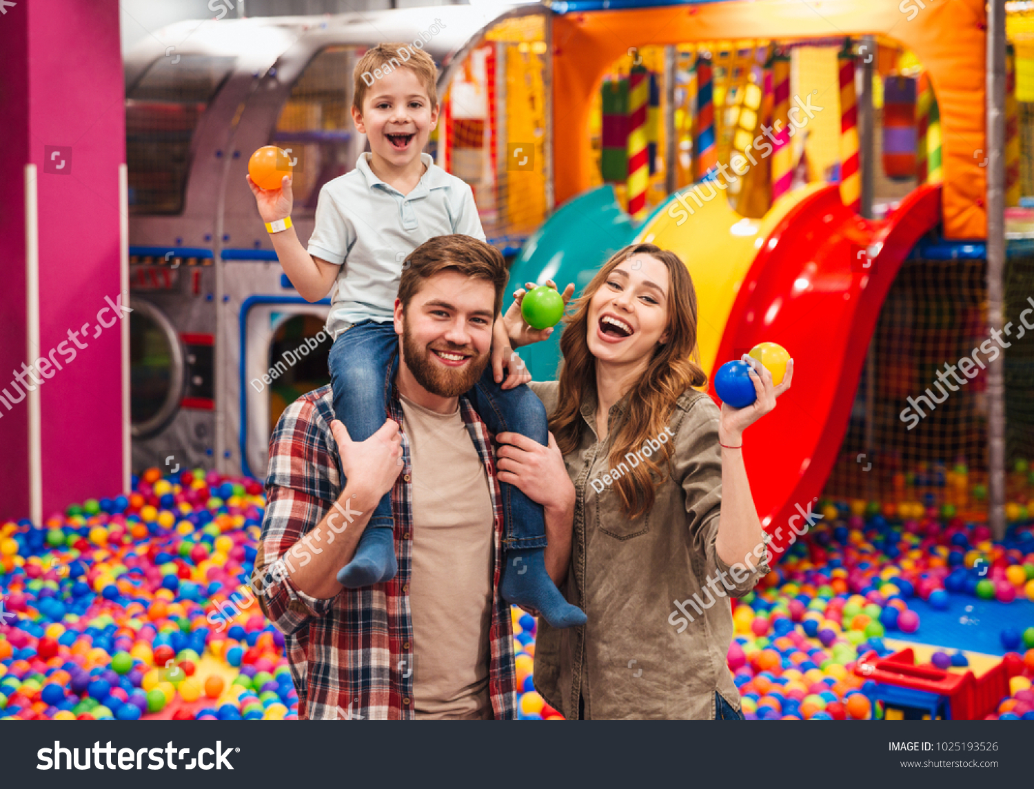 Image of emotional cheerful little child have fun with his parents in entertainment game center. #1025193526
