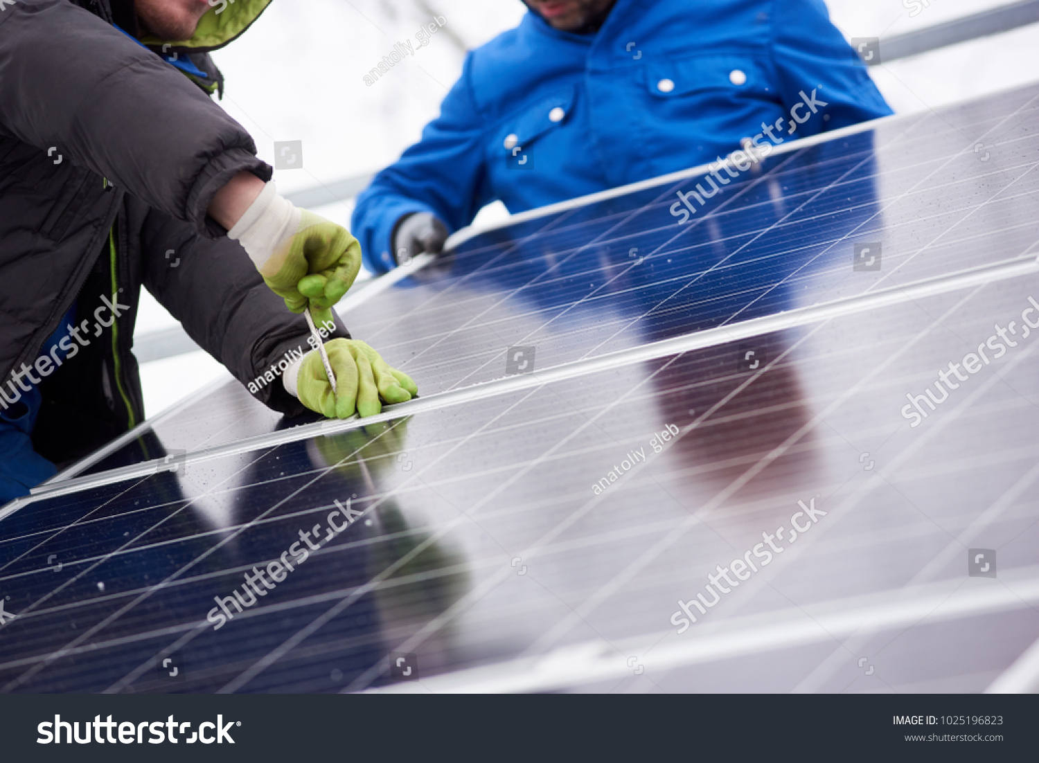 Cropped shot of professional electricians working on solar power plant factory renewable energy electricity alternative source environment friendly green photovoltaic farm occupation modern technology #1025196823