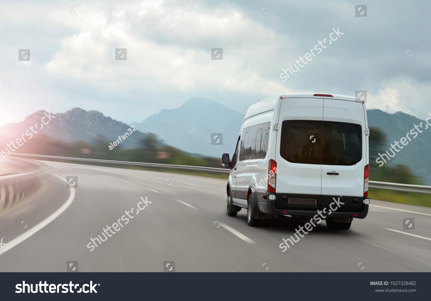 passenger bus van accelerating on a background of mountains #1027328482