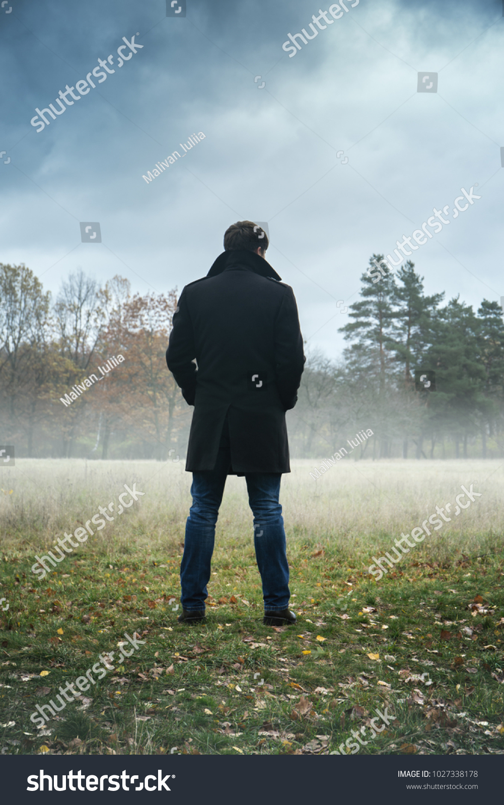 A man in a black coat in foggy weather #1027338178