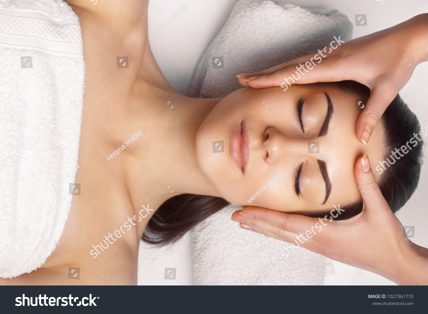 Face massage.  Close-up of young woman getting spa massage treatment at beauty spa salon.Spa skin and body care. Facial beauty treatment.Cosmetology. #1027361710