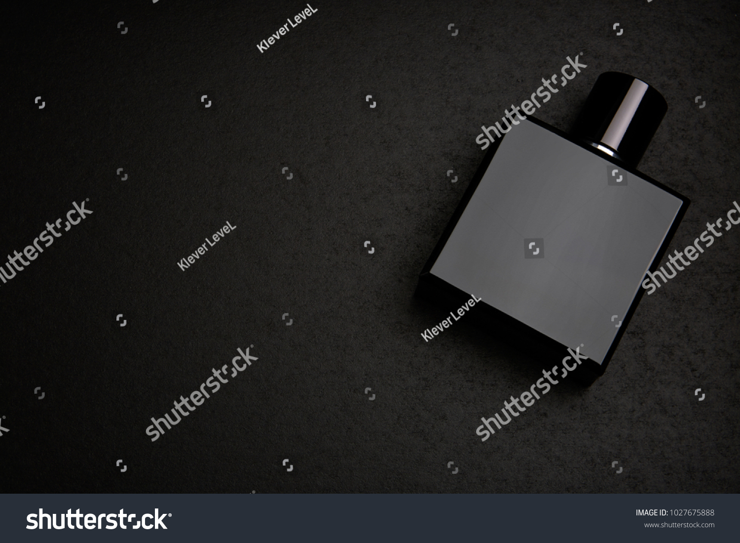 Mockup of black fragrance perfume bottle mockup on dark empty background. Top view. Horizontal #1027675888
