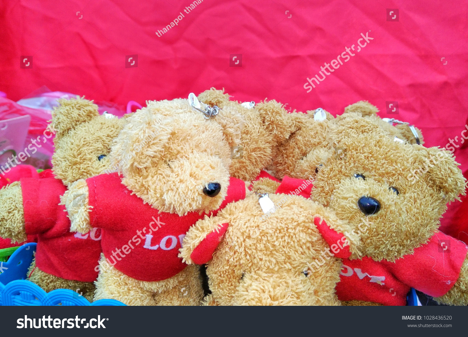 Teddy bear with red flower in the heart of Valentine's Day #1028436520
